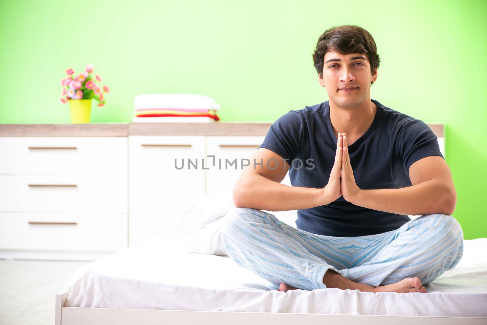 Young man in pajamas doing morning exercises  by Elnur