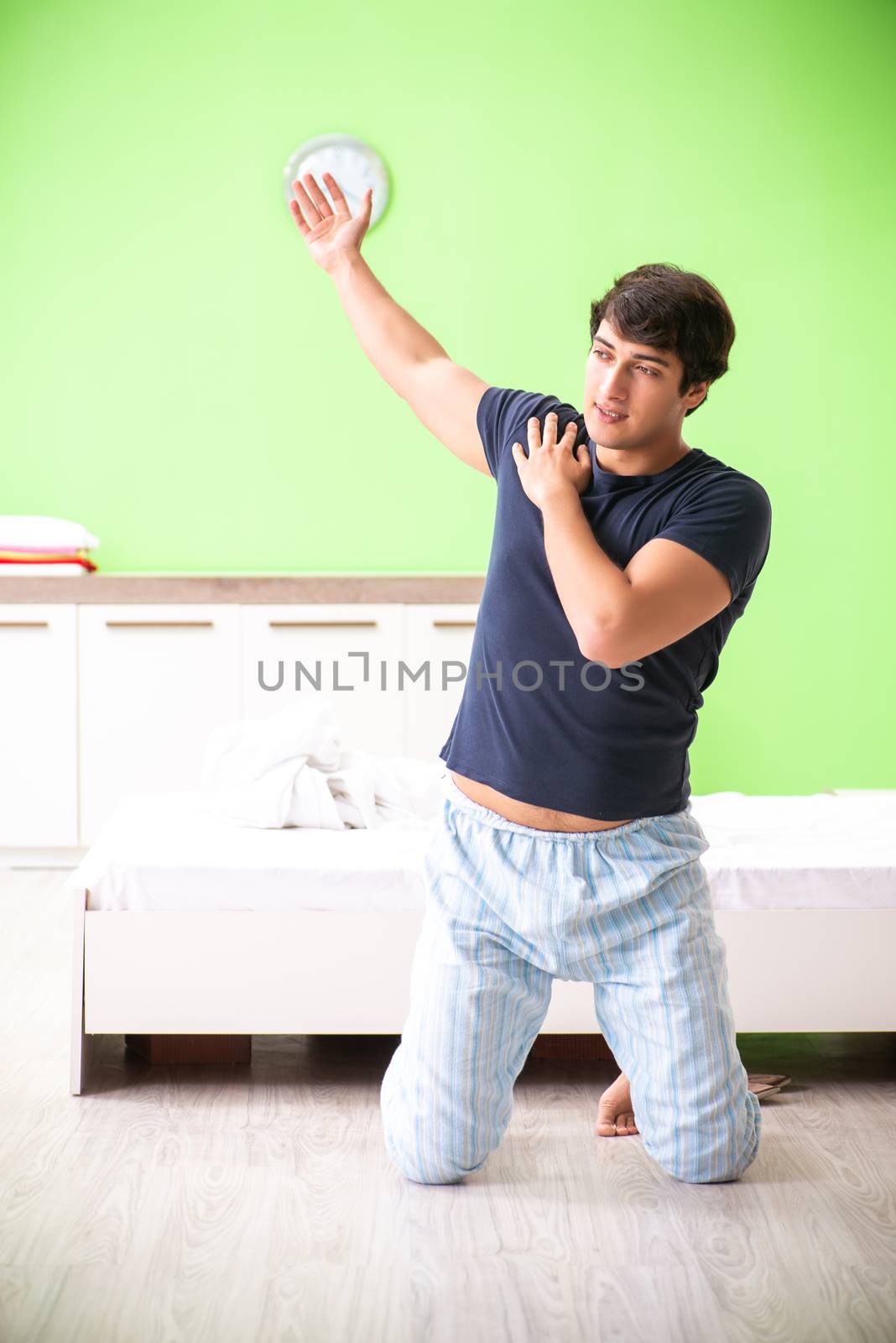 Young man in pajamas doing morning exercises 