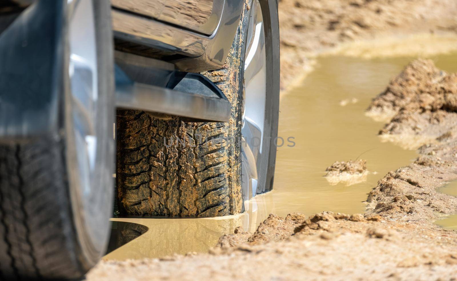 Suv 4wd car rides through deep muddy puddle