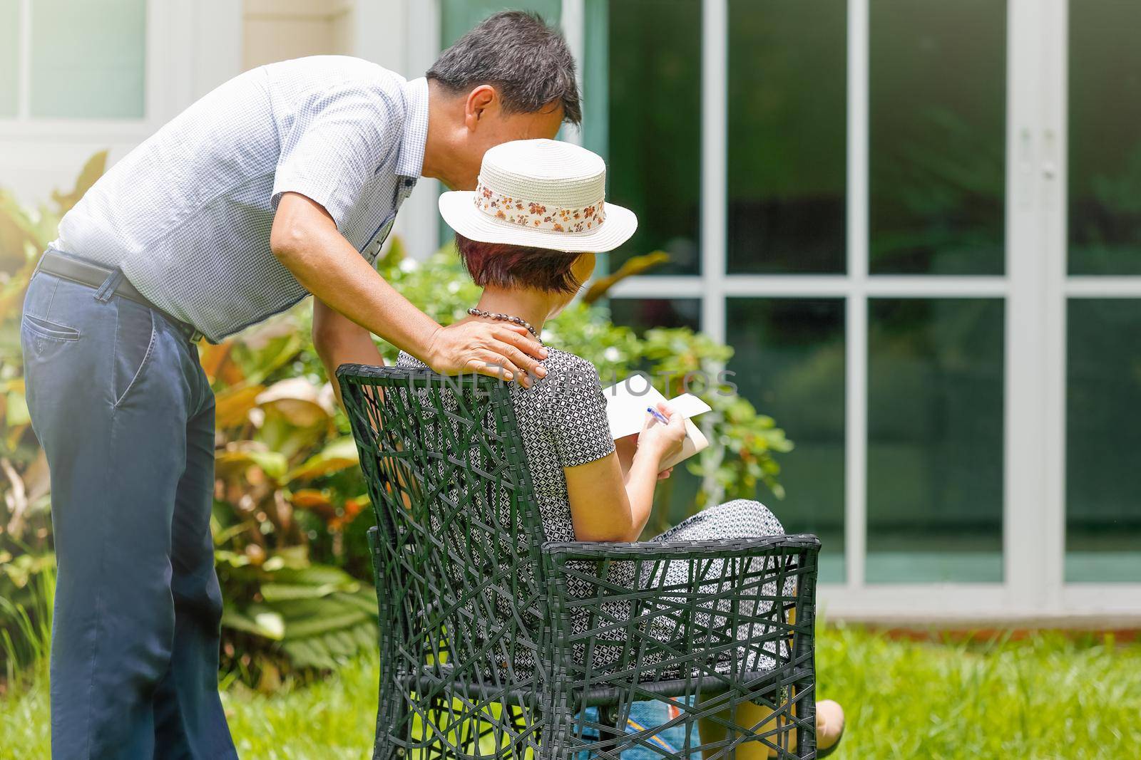 Asian middle aged couple sitting and relax in backyard