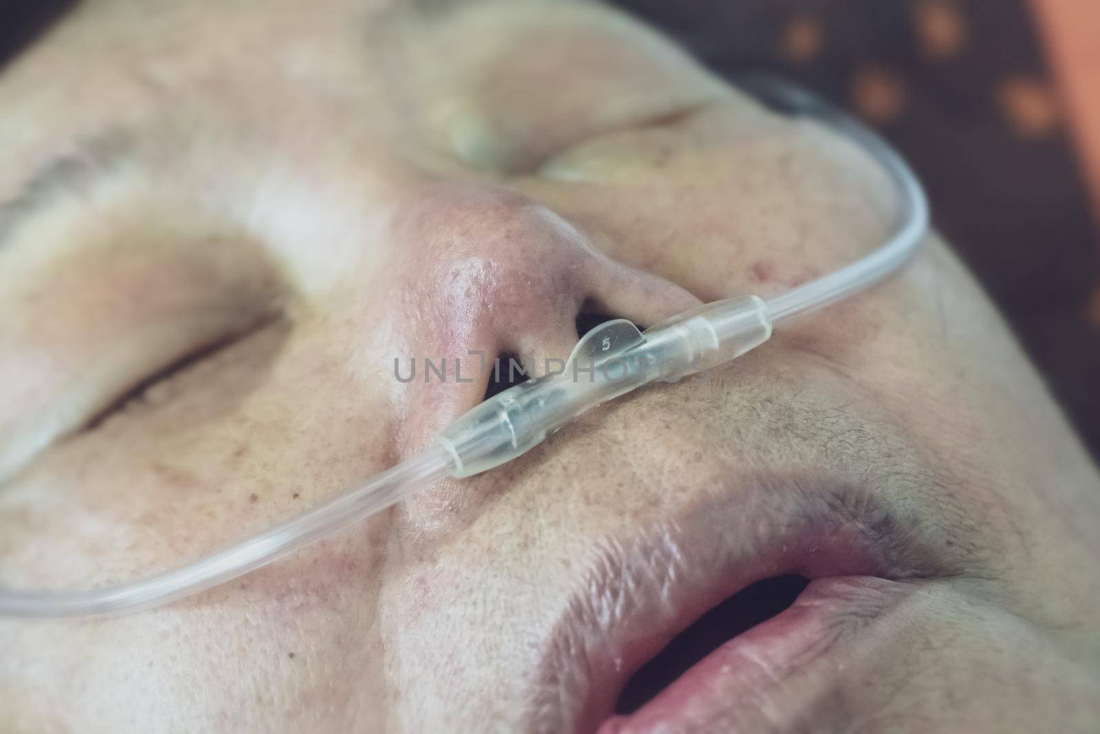 Elderly woman with nasal breathing tube to help with her breathing at home