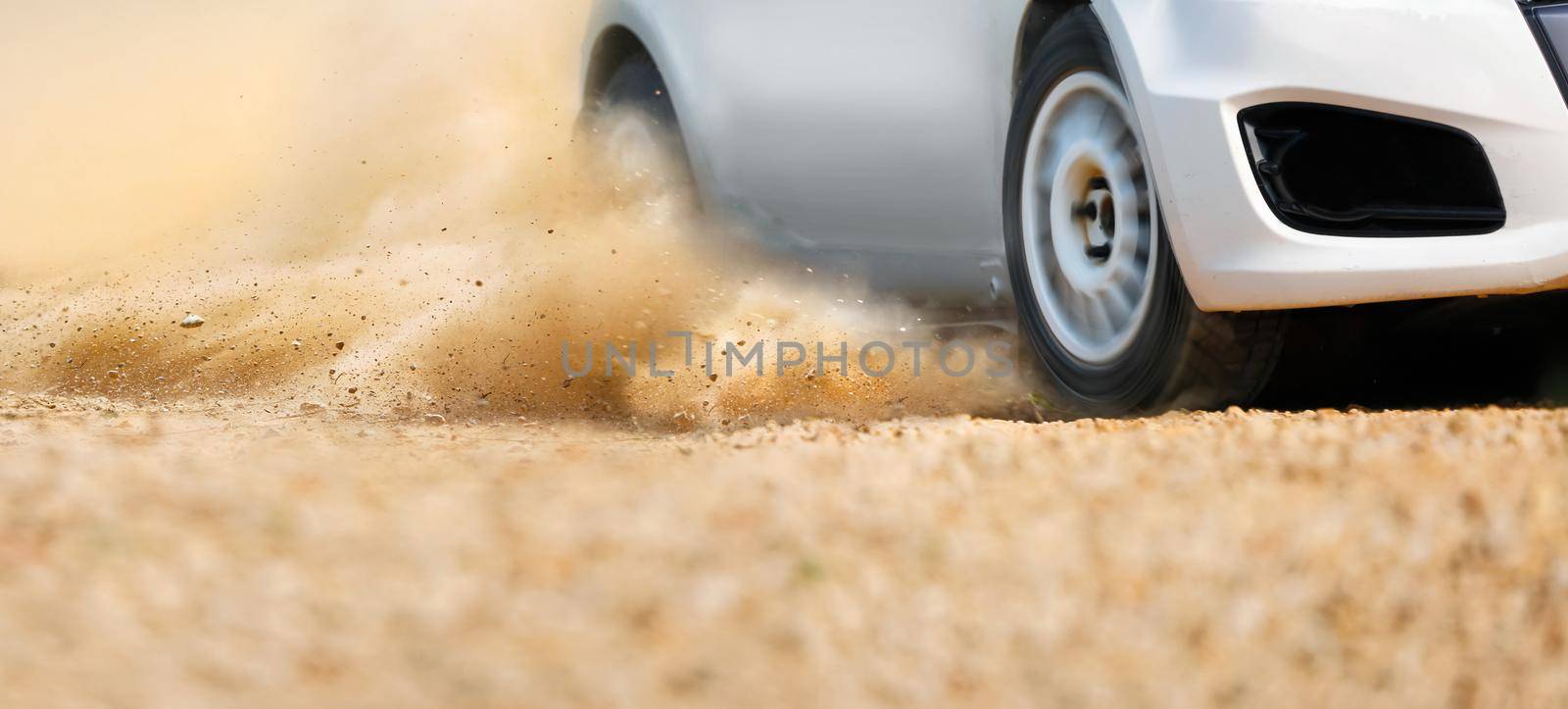 Rally race car drifting on dirt track.