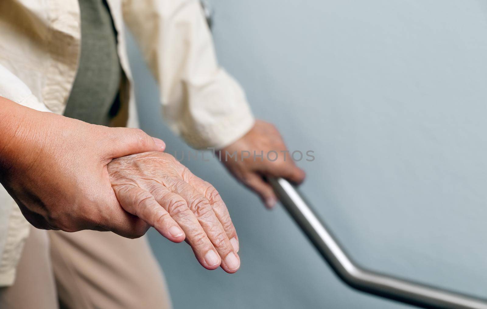 Elderly woman holding on handrail with caregiver by toa55