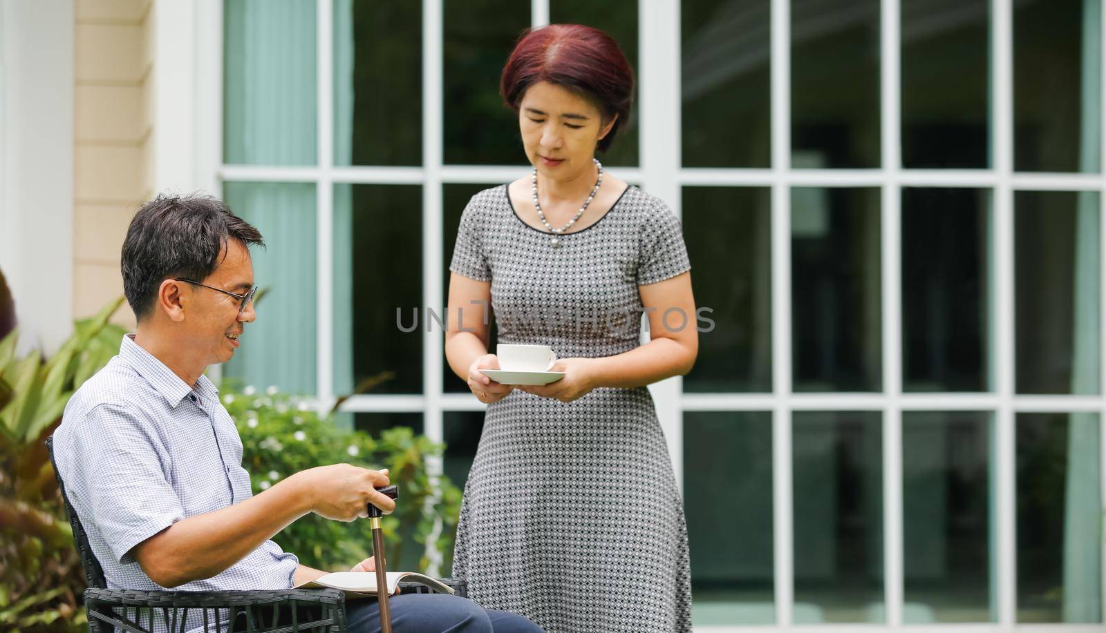 Senior male sitting and relax in backyard with wife