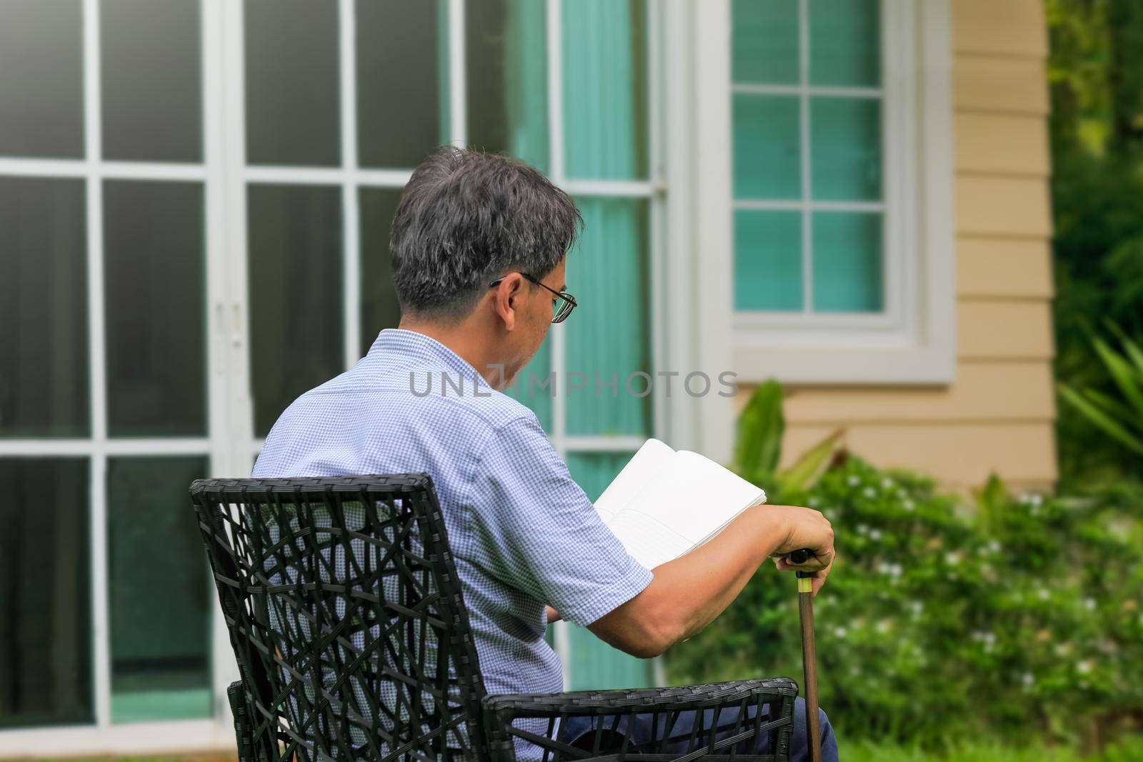 Senior male reading and relax in backyard by toa55