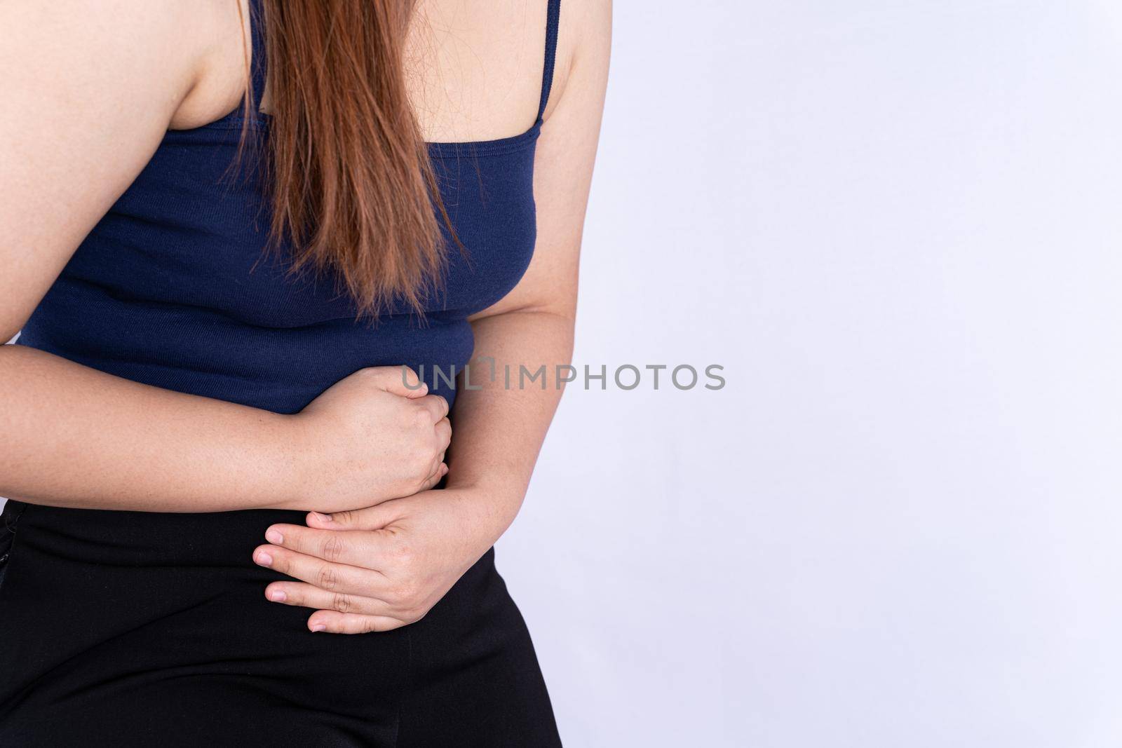 Woman suffering from stomach pain and injury isolated grey background. by mikesaran