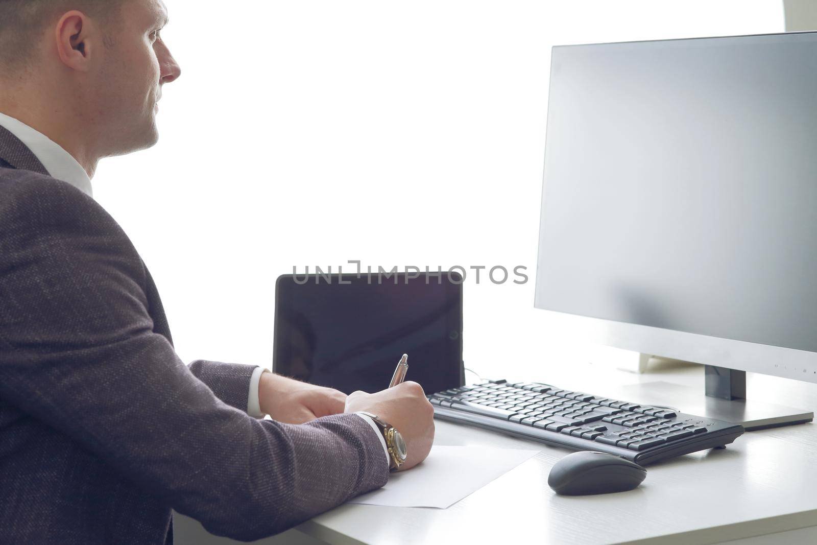 Young business man working at the computer and papers on the table. 