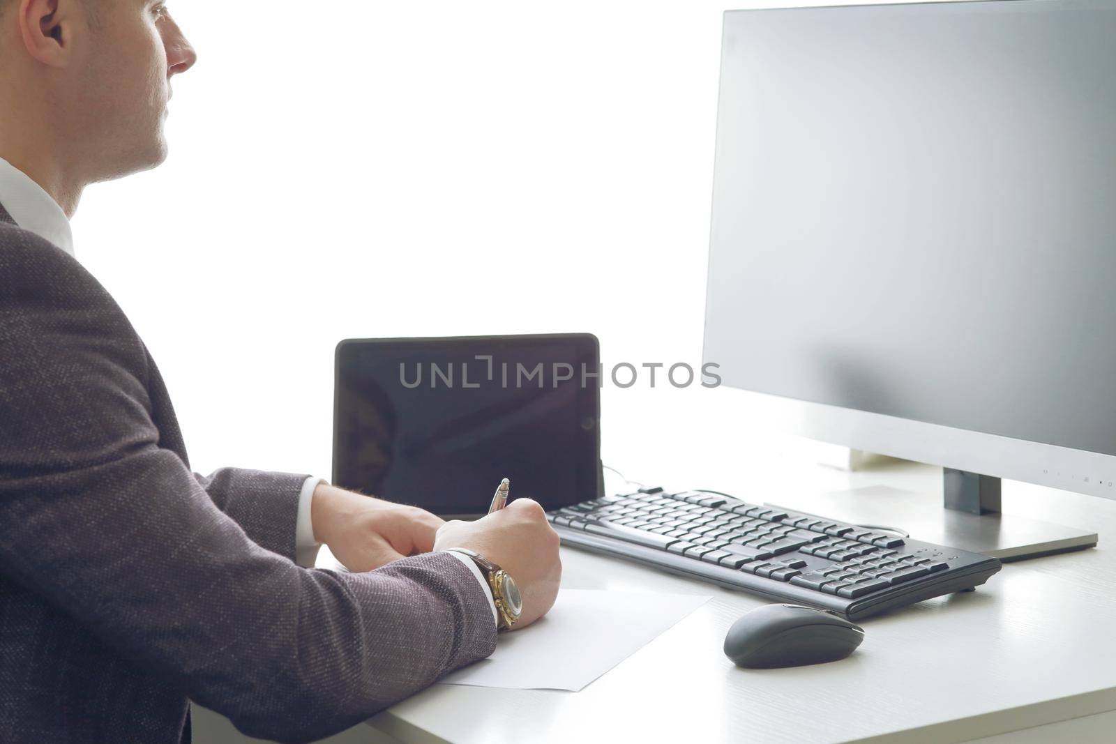 Young business man working at the computer and papers on the table. 