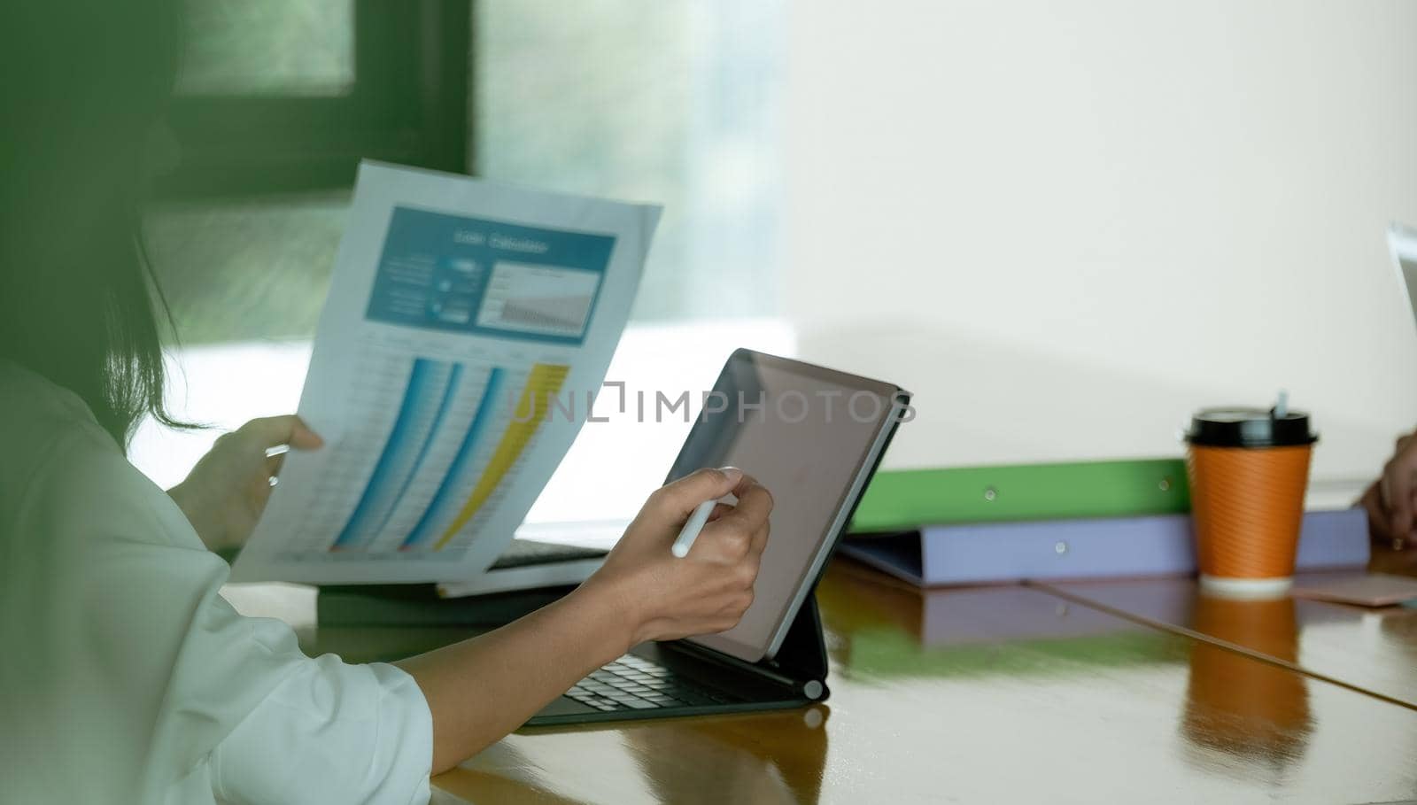 Close up hand of businesswoman working with smart tablet on financial document report.