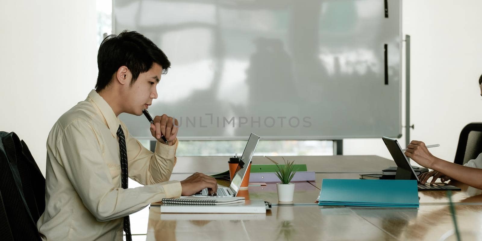 Concentrate Young Asian Businessman Working on Computer Laptop in Office. by nateemee