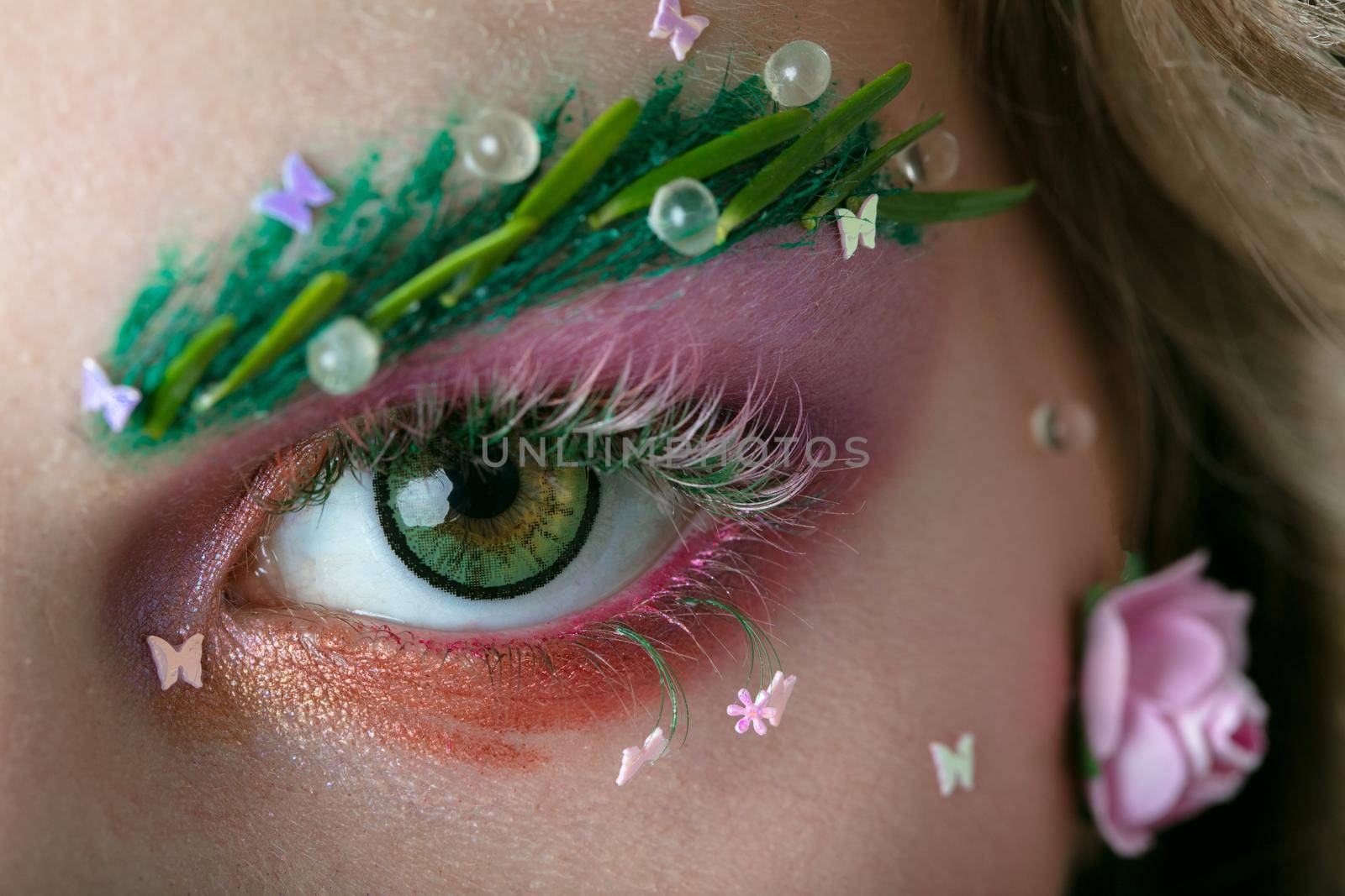 Eyes of a girl model with extended eyebrows and eyelashes. Part of the face with bright spring makeup. by Sviatlana