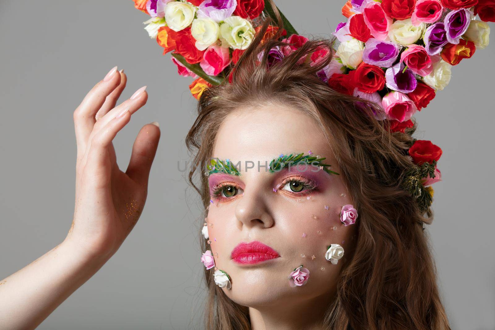 Beautiful girl in flower makeup. Spring or summer beauty. Fantastic woman with extended eyebrows and eyelashes.