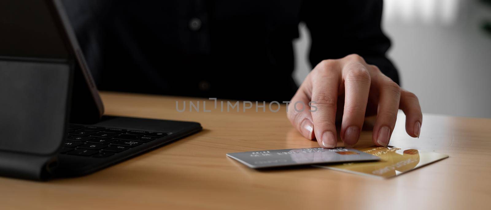 Close up hand of woman using credit card for online payment with smart teblet by nateemee