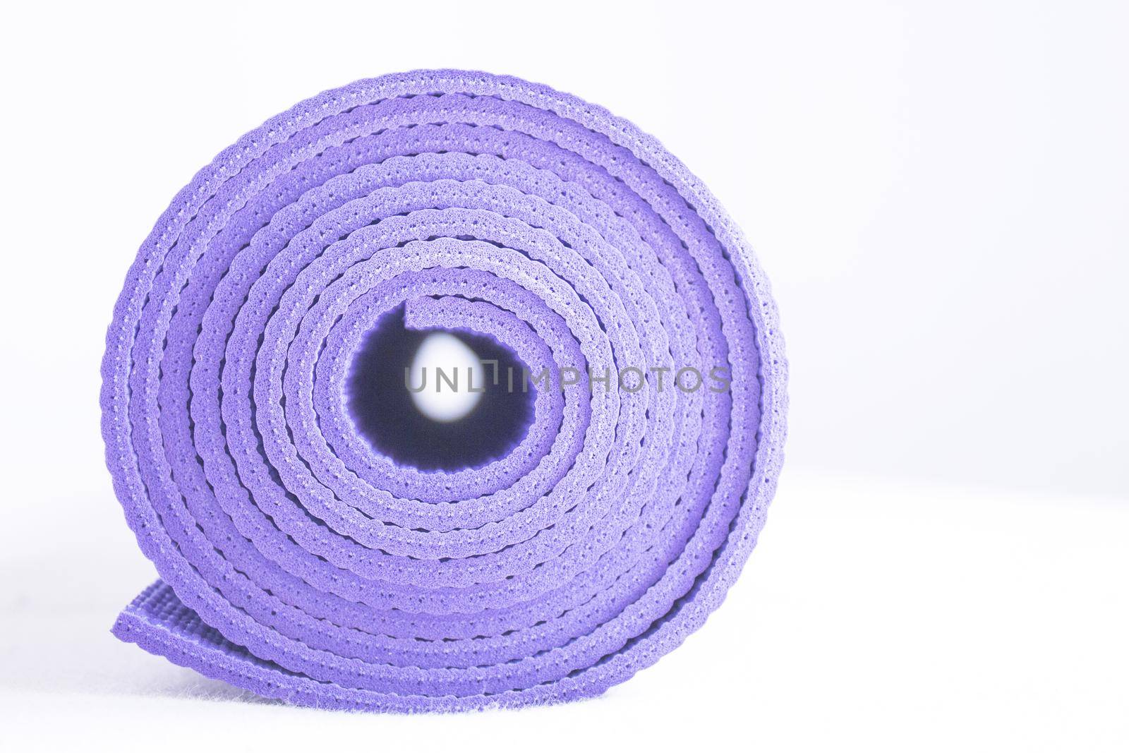 Rolled up yoga or pilates mat. No people