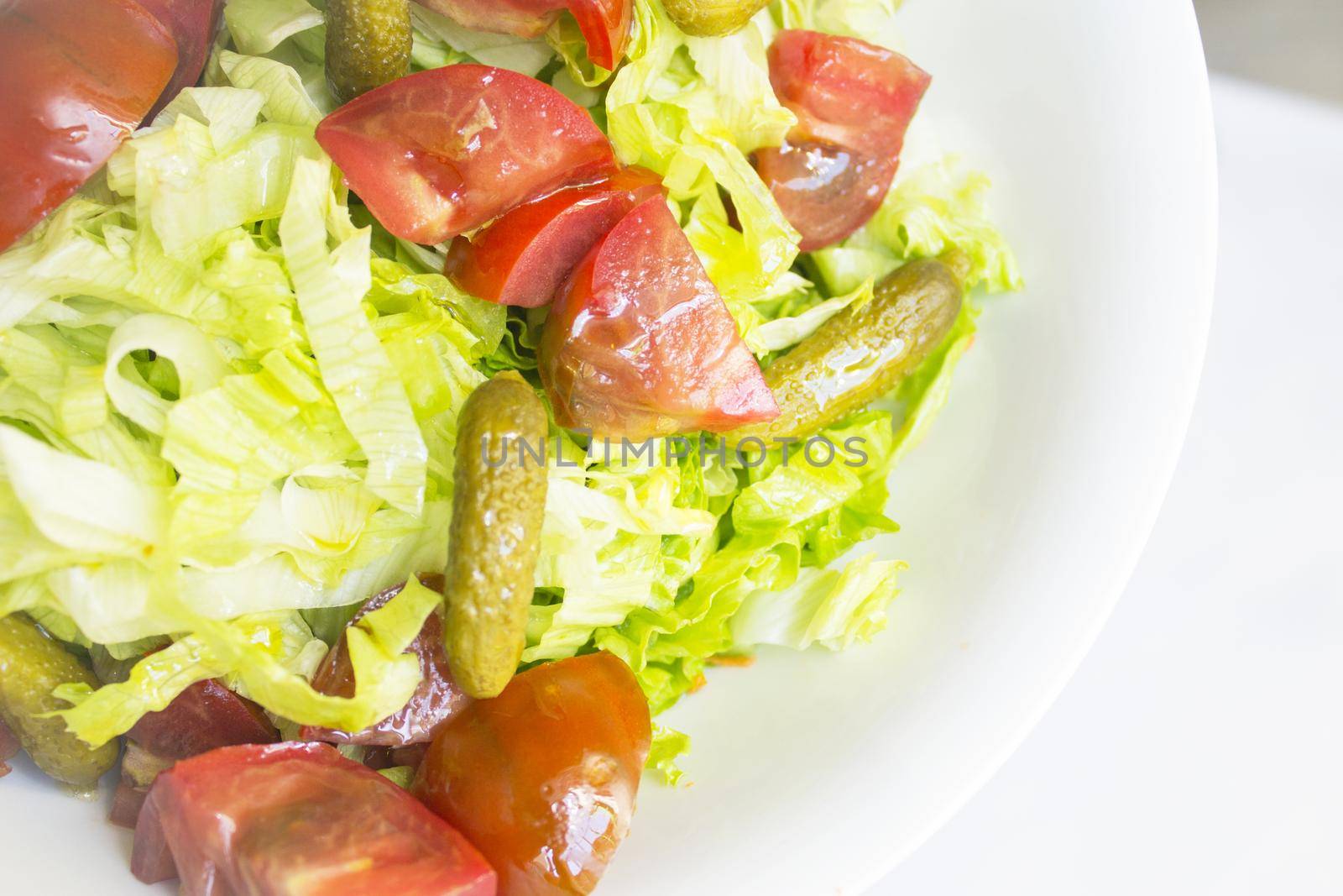 Lettuce salad with tomato and pickles. Raw food