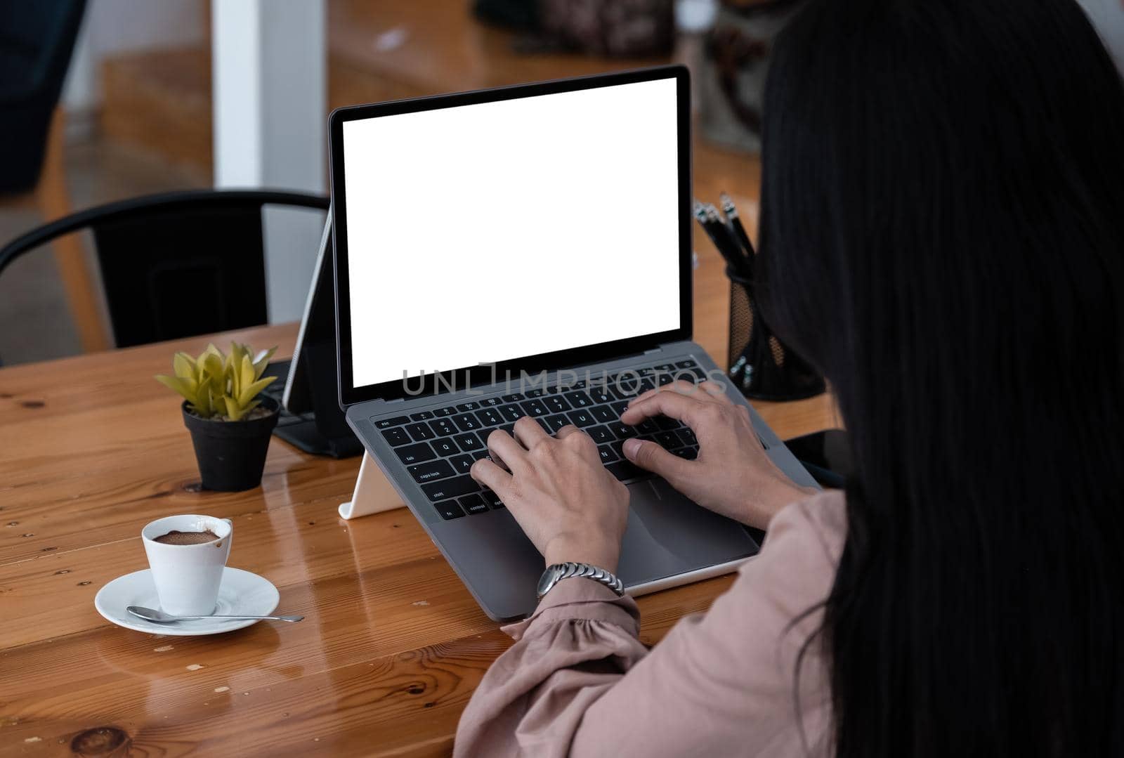 Young woman using laptop computer with blank white screen for business working at cafe by nateemee