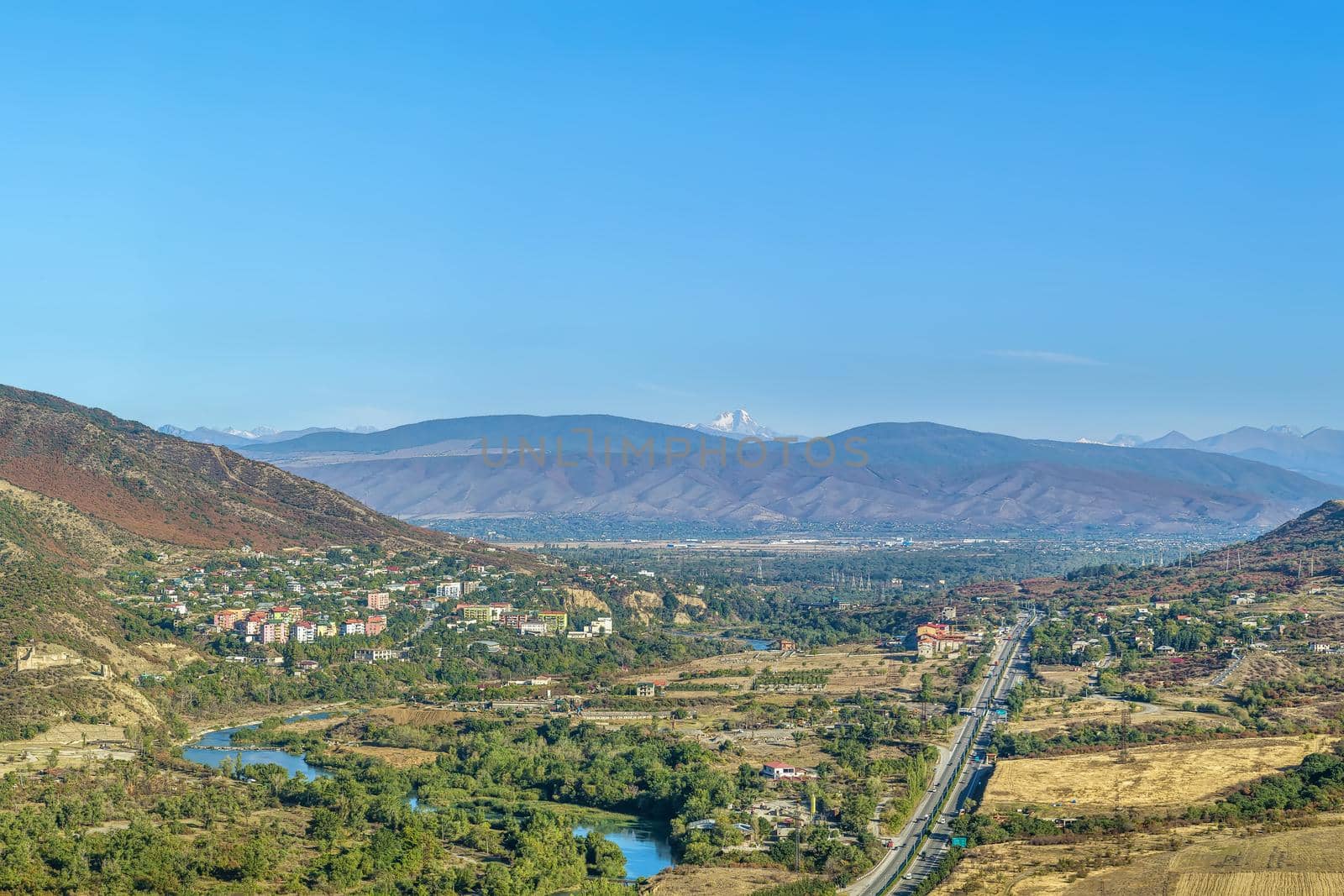 View of Aragvi valley from Jvari Monastery hill, Georgia. On the horizon is visible Mount Kazbek