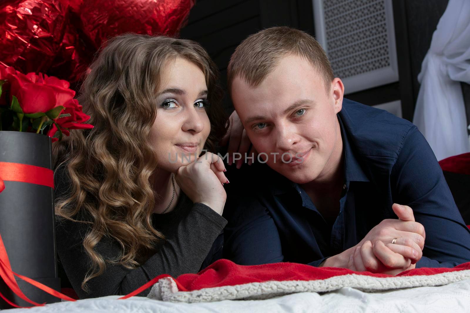 Portrait of a beautiful young couple. A man and a woman are lying on the floor. Lovers.