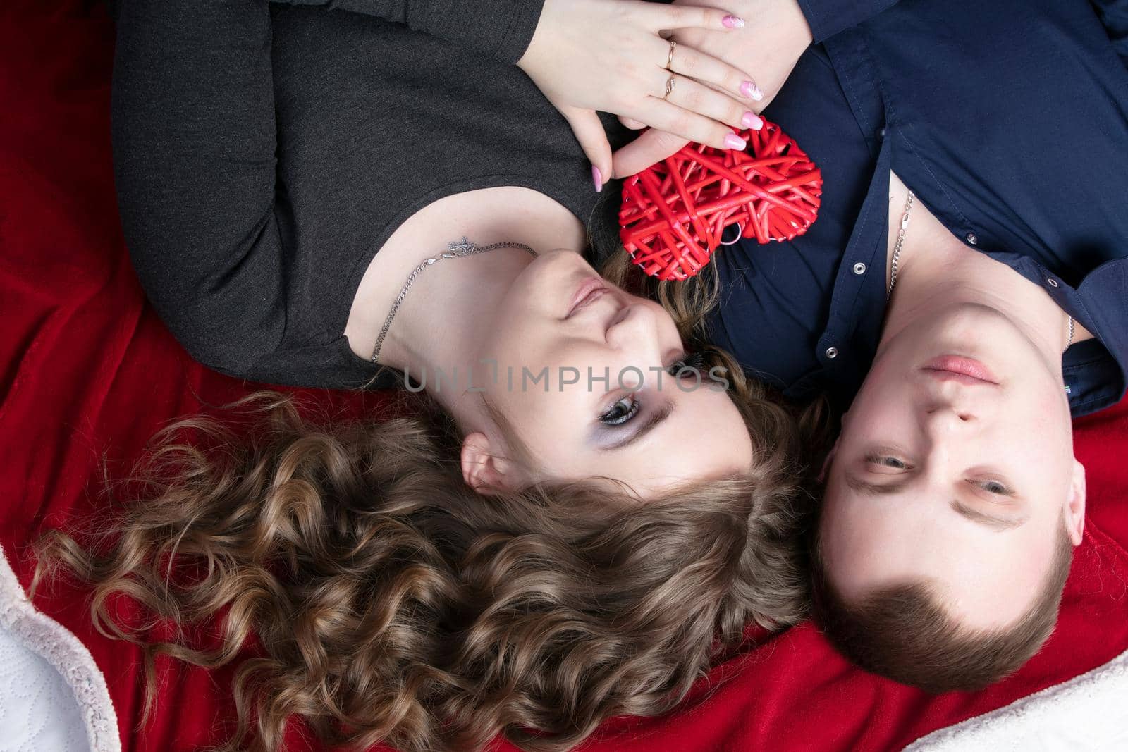 Loving couple from top to bottom. Man and woman with a red heart. Beautiful young husband and wife.Close-up man and woman together.Valentine's day.