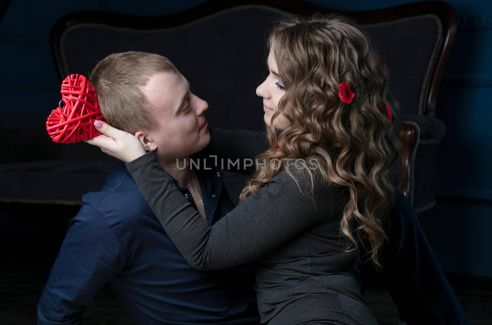 Young couple on Valentine's day. Lovers. Girl and guy with a red heart. Romantic date.