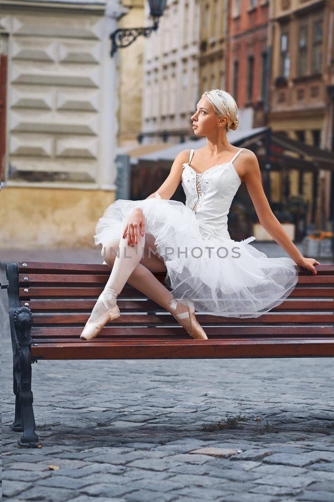 Attractive ballerina sitting on the bench in the city by SerhiiBobyk