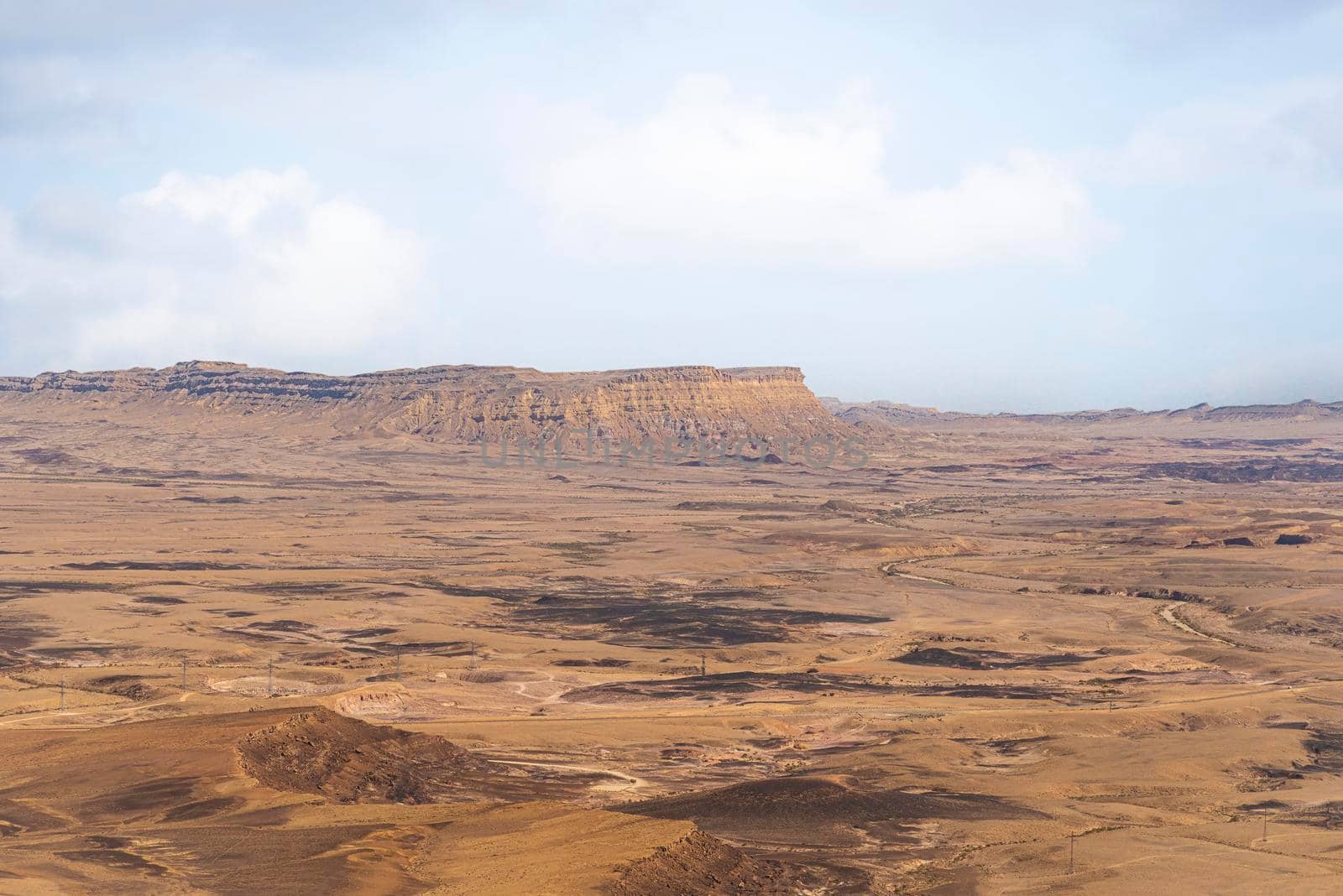 Ramon Crater Makhtesh Ramon, the largest in the world, as seen from the high rocky cliff edge surrounding it from the north, Ramon Nature reserve, Mitzpe Ramon, Negev desert, Israel. High quality photo