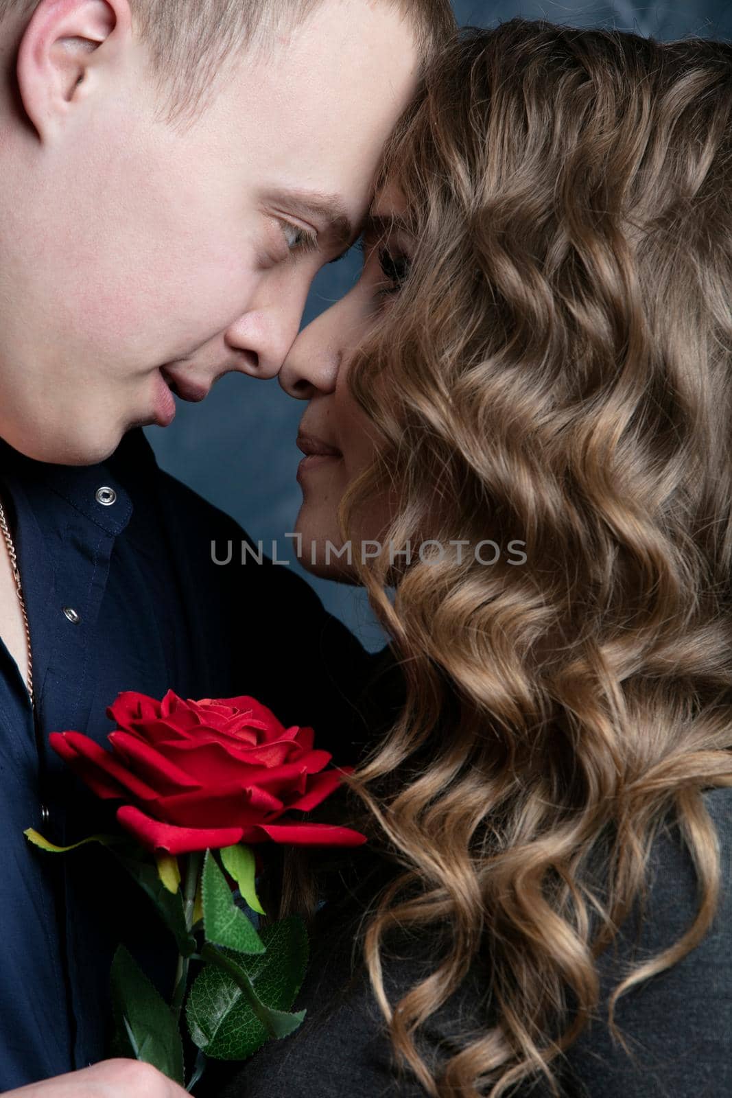 Profile of a beautiful girl and guy with a red rose on the guy’s shoulder. Valentine's Day. Lovers. Romantic date. by Sviatlana