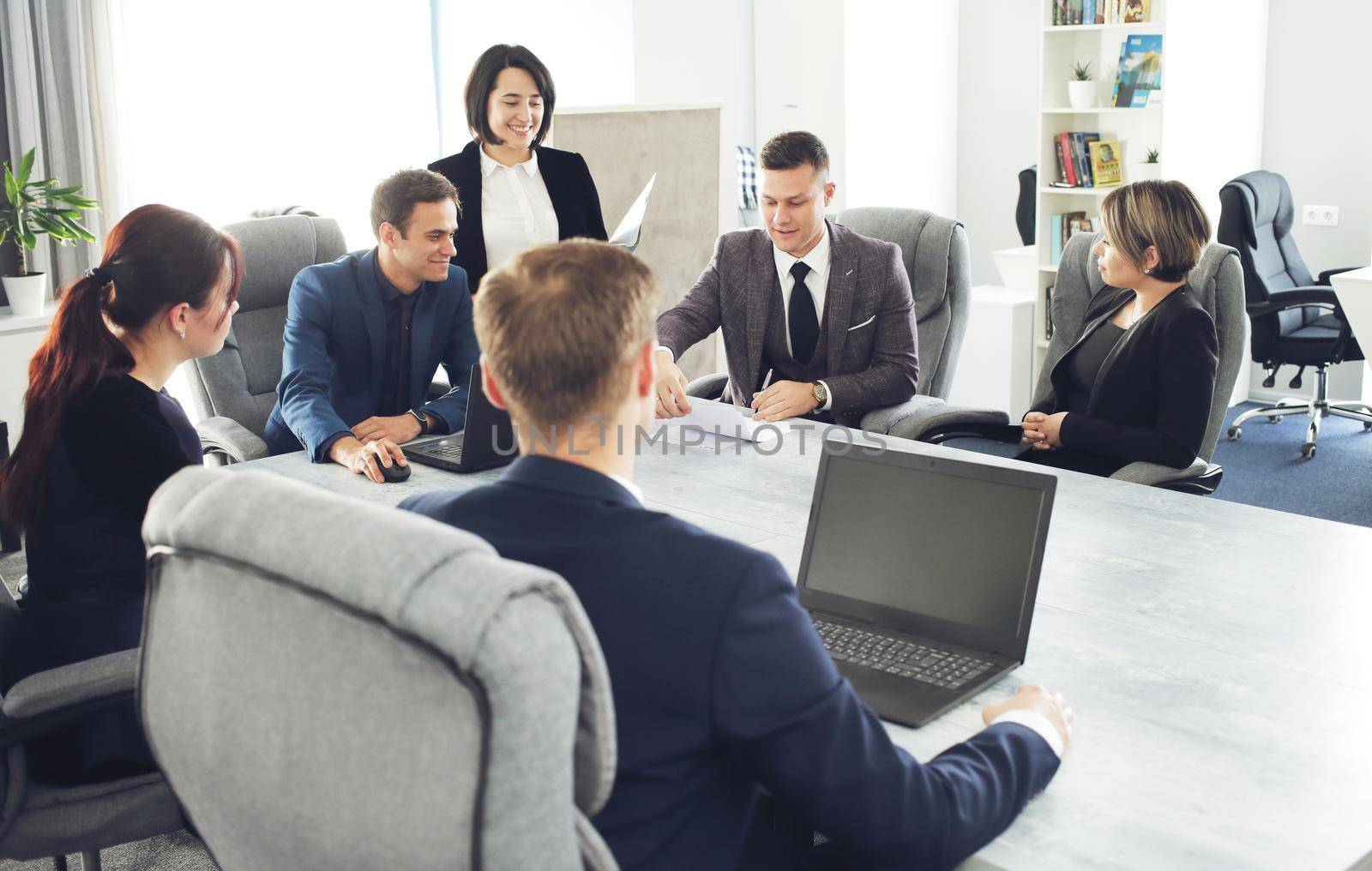 Group of young successful businessmen lawyers communicating together in a conference room while working on a project by selinsmo