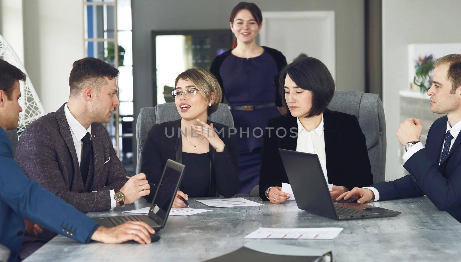 Group of young successful businessmen lawyers communicating together in a conference room while working on a project. 