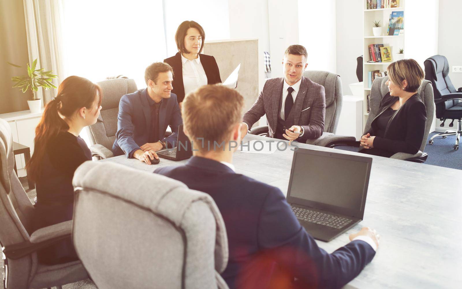 Group of young successful businessmen lawyers communicating together in a conference room while working on a project by selinsmo