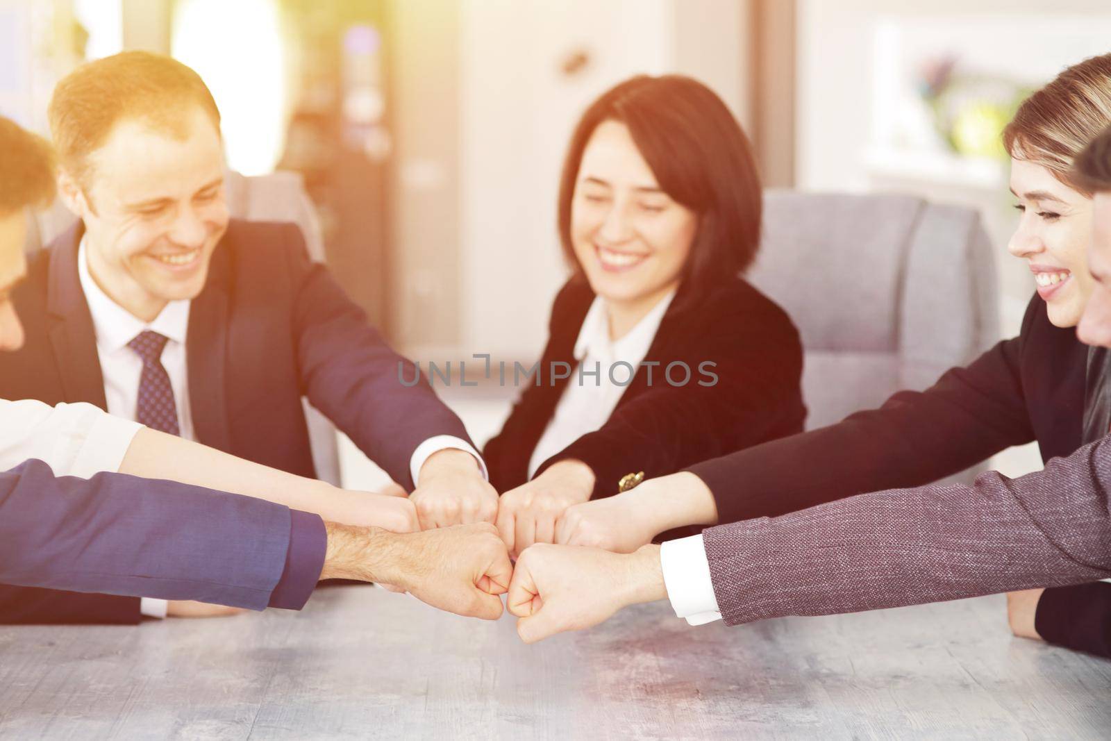 Unity and teamwork concept of young business people folding their hands together. 