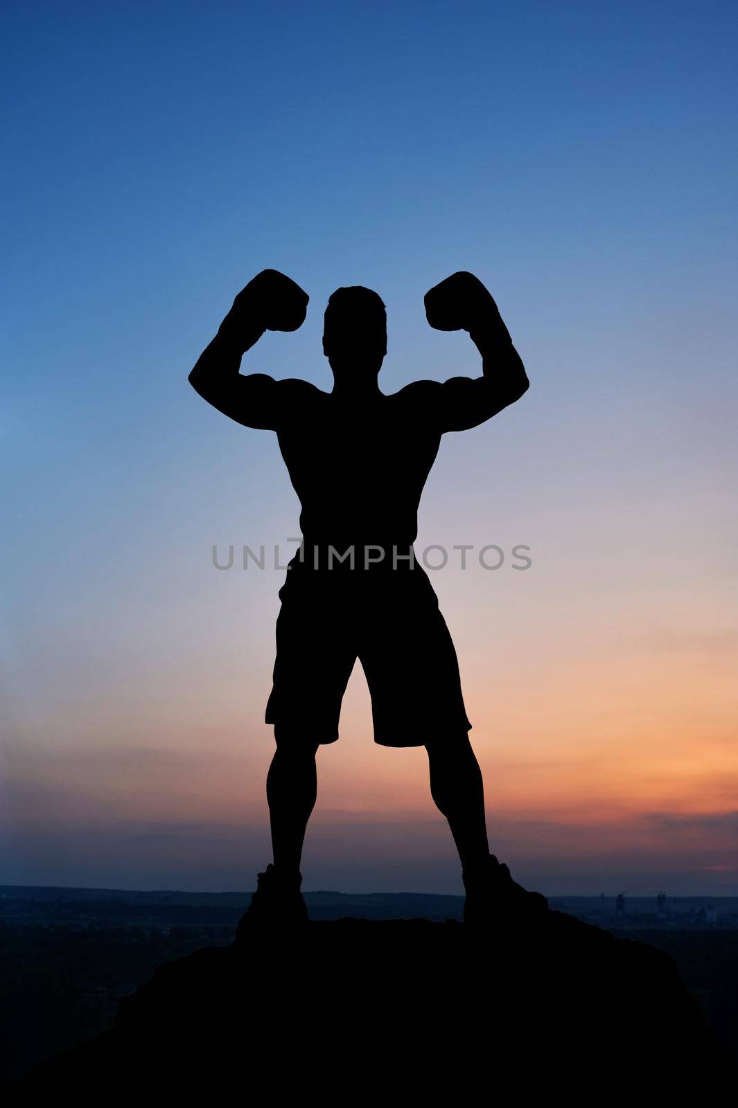 Silhouette of a muscular strong man flexing his muscles standing outdoors stunning sunset scenery on the background guy mysterious incognito sportsperson sportsman boxer fighter bodybuilder