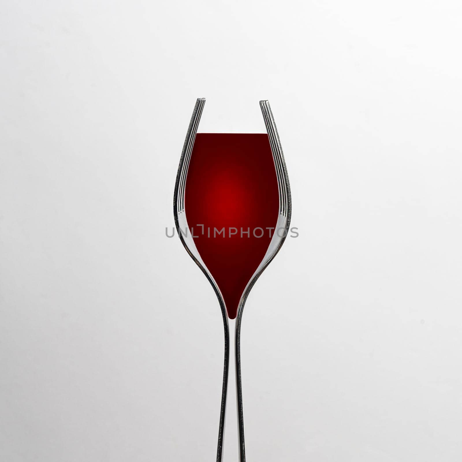 red wine in a glass formed with two forks