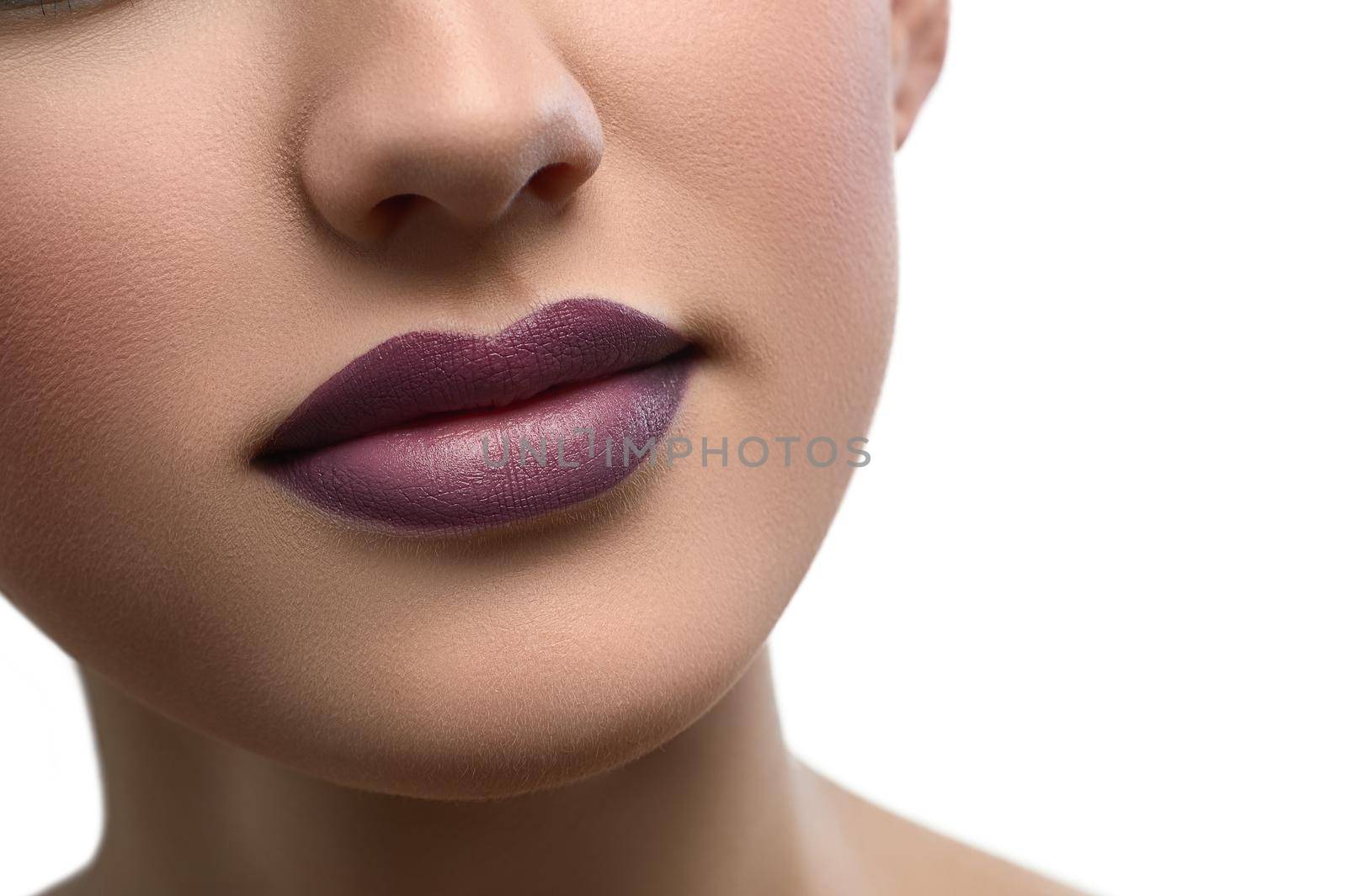 Close up shot of a beautiful smile of a woman with full sexy lips covered with purple lipstick isolated copyspace beauty fashion skin unblemished augmentation fillers cosmetology makeup visage .
