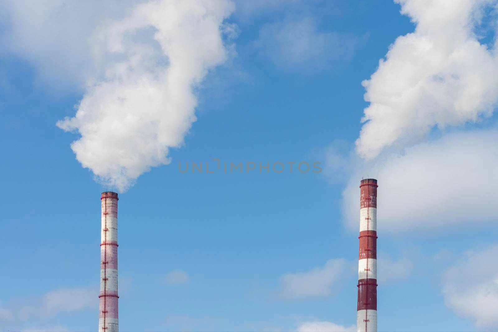 Two pipes and smoke from them against the blue sky. Industrial landscape. Front and bottom view. by Essffes