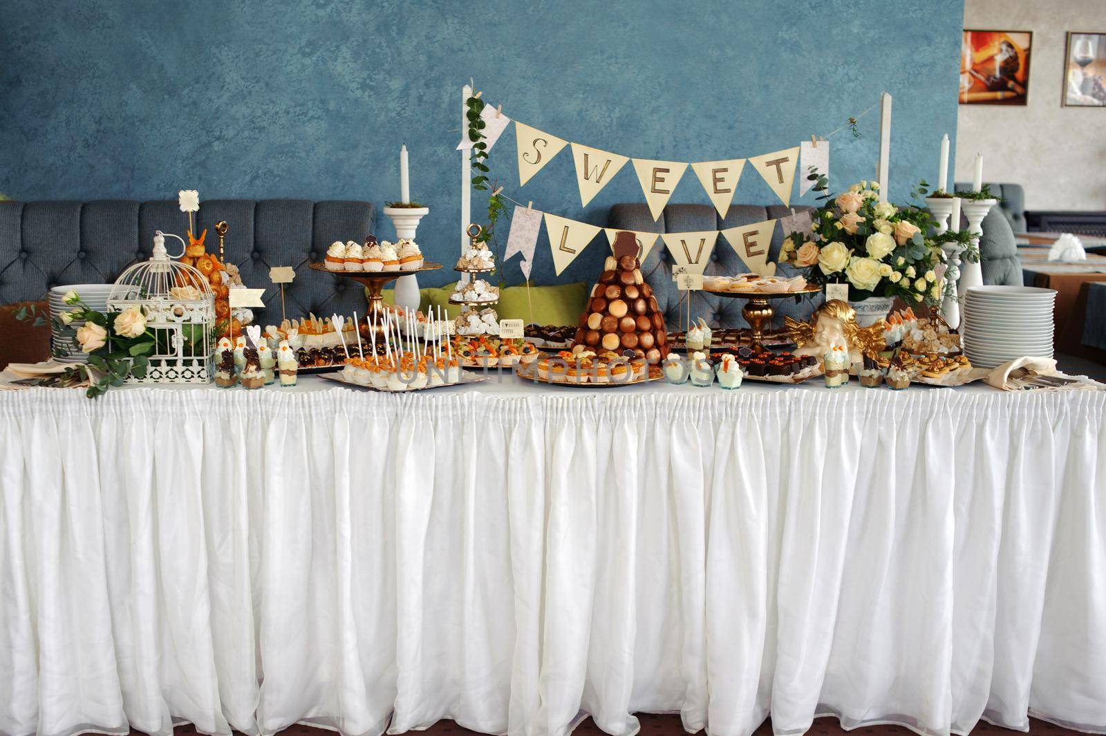 banquet table with sweets on white tablecloth, decor dessert table with appetizers