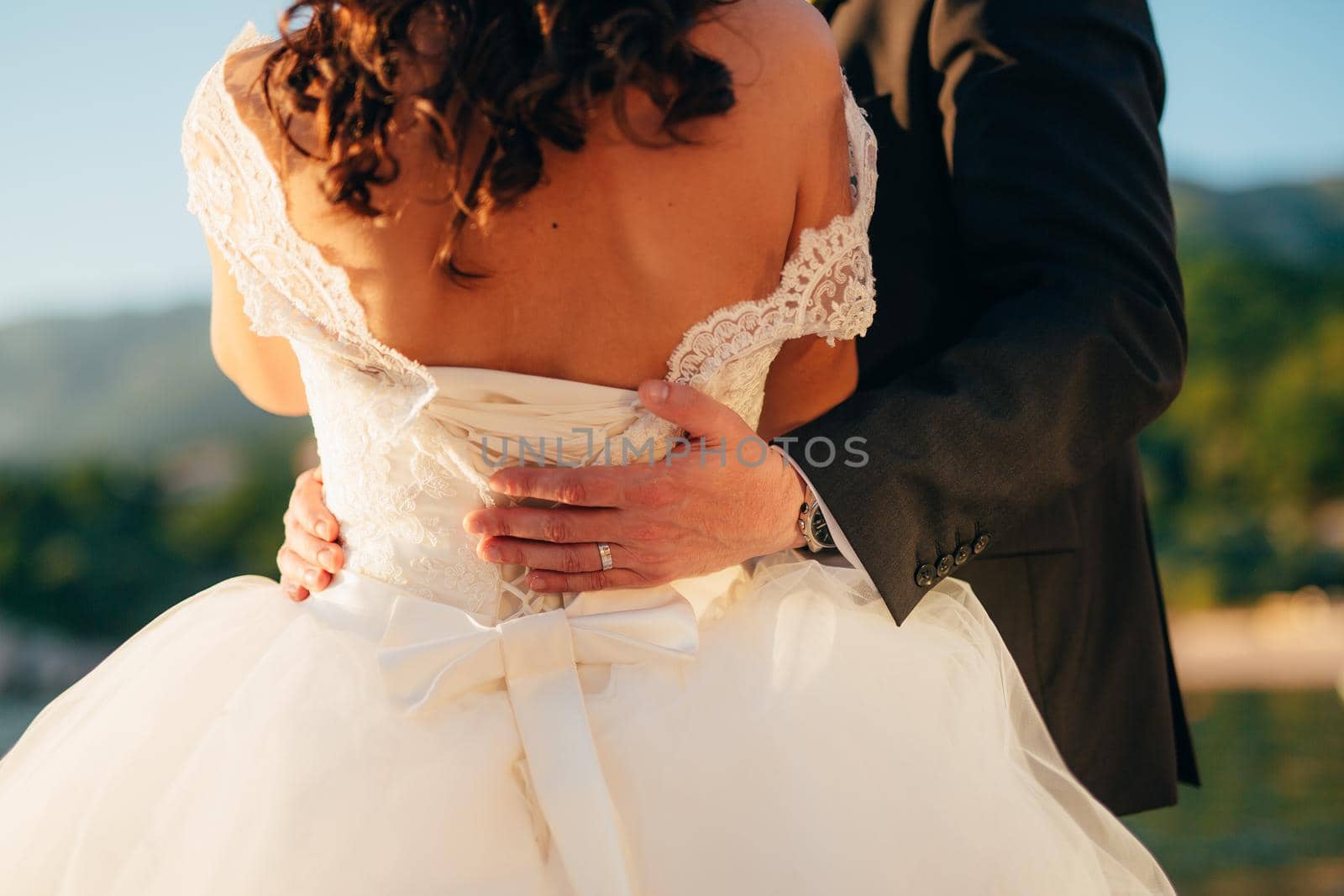 The groom embraces the bride on the beach. Wedding in Montenegro and Croatia.