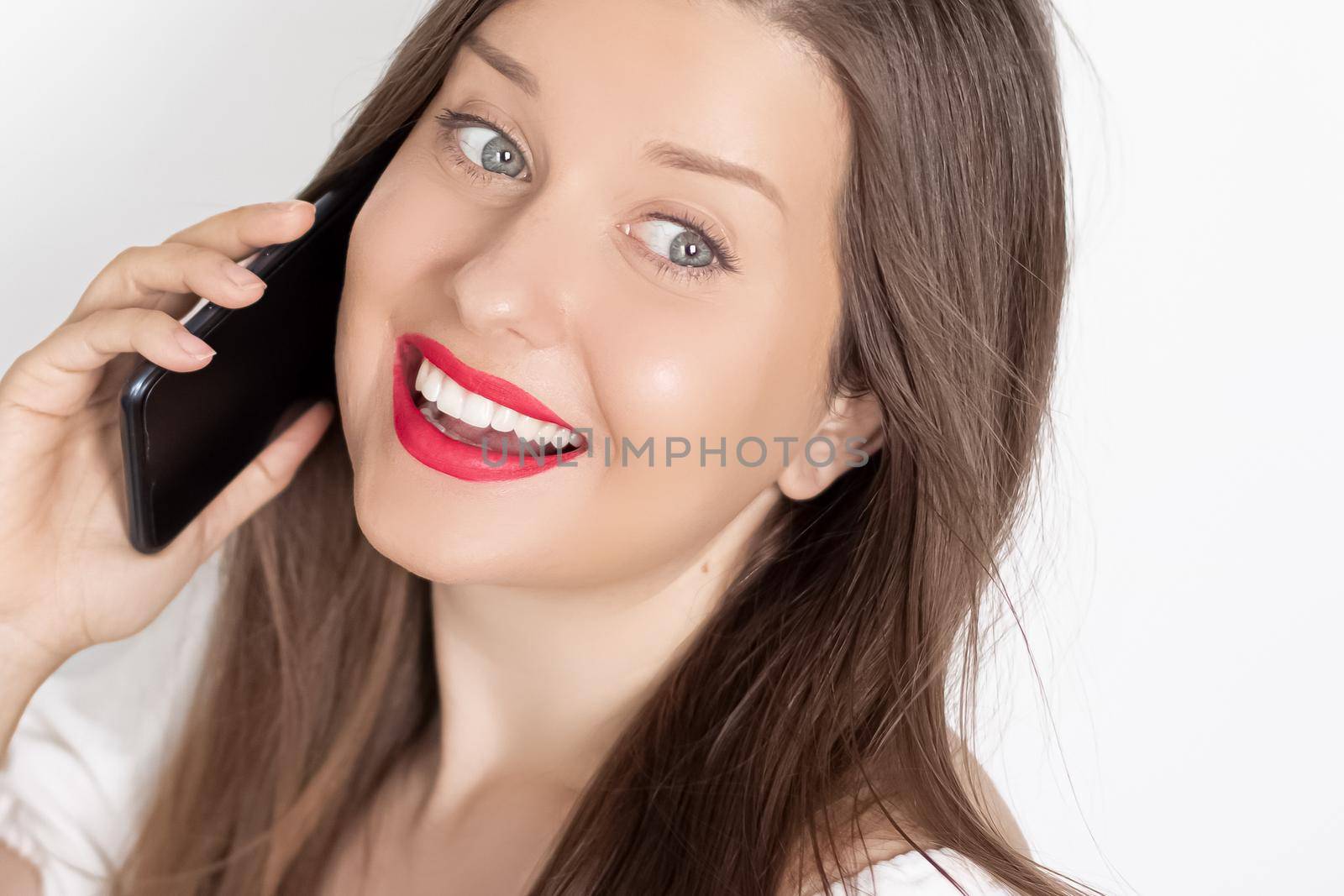 Happy smiling woman calling on smartphone, portrait on white background. People, technology and communication concept by Anneleven