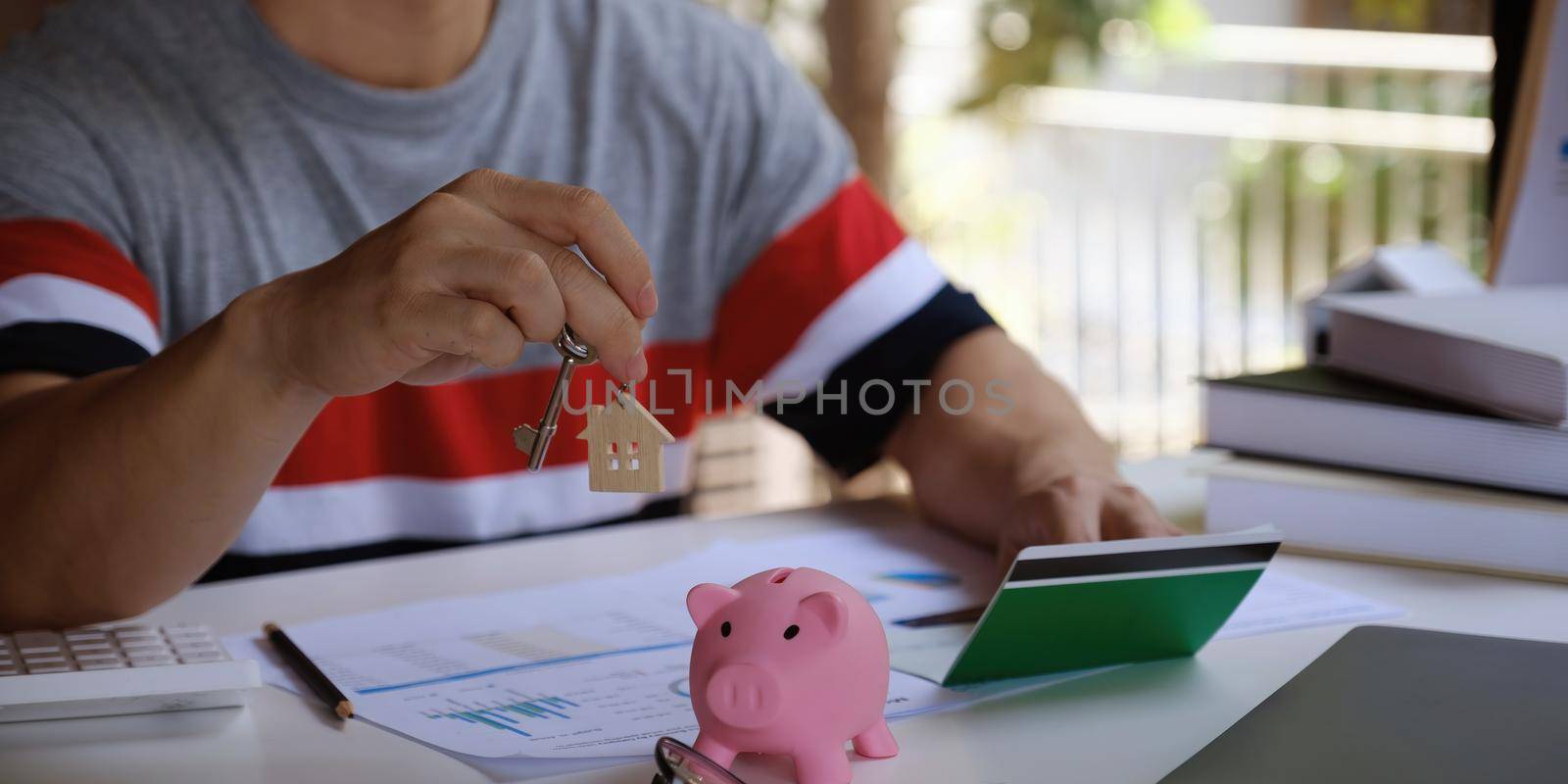 Before buying a home, a man checks the amount of money in his savings account. House for sale by a real estate broker