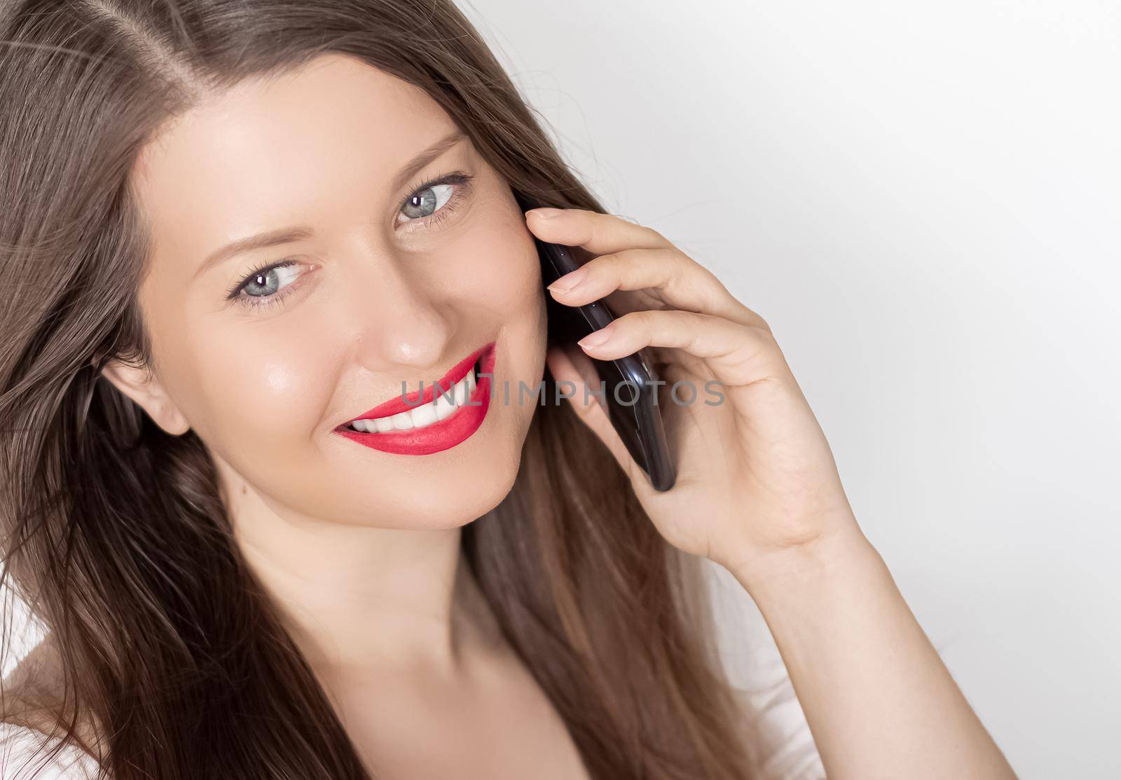 Happy smiling woman calling on smartphone, portrait on white background. People, technology and communication concept.