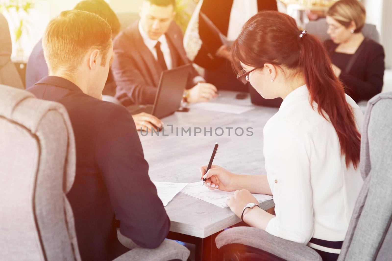 Group of young successful businessmen lawyers communicating together in a conference room while working on a project by selinsmo