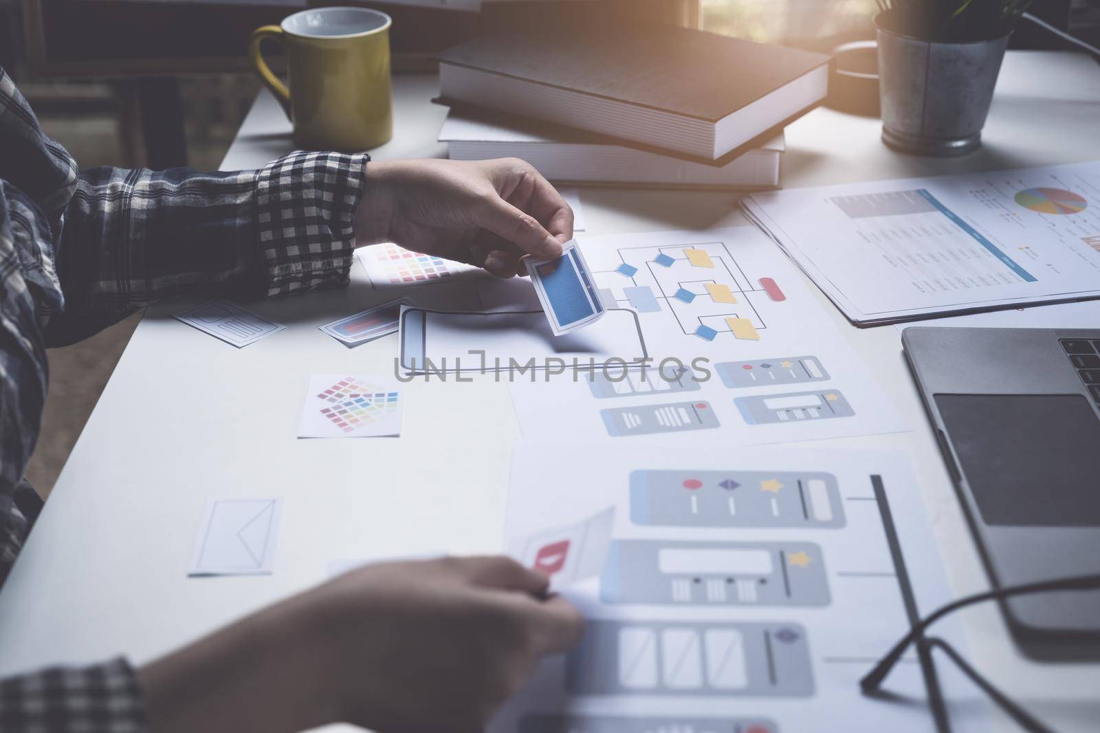 Closeup of male ux developer and ui designer about mobile phone app interface in living room at home. Creative digital development agency concept