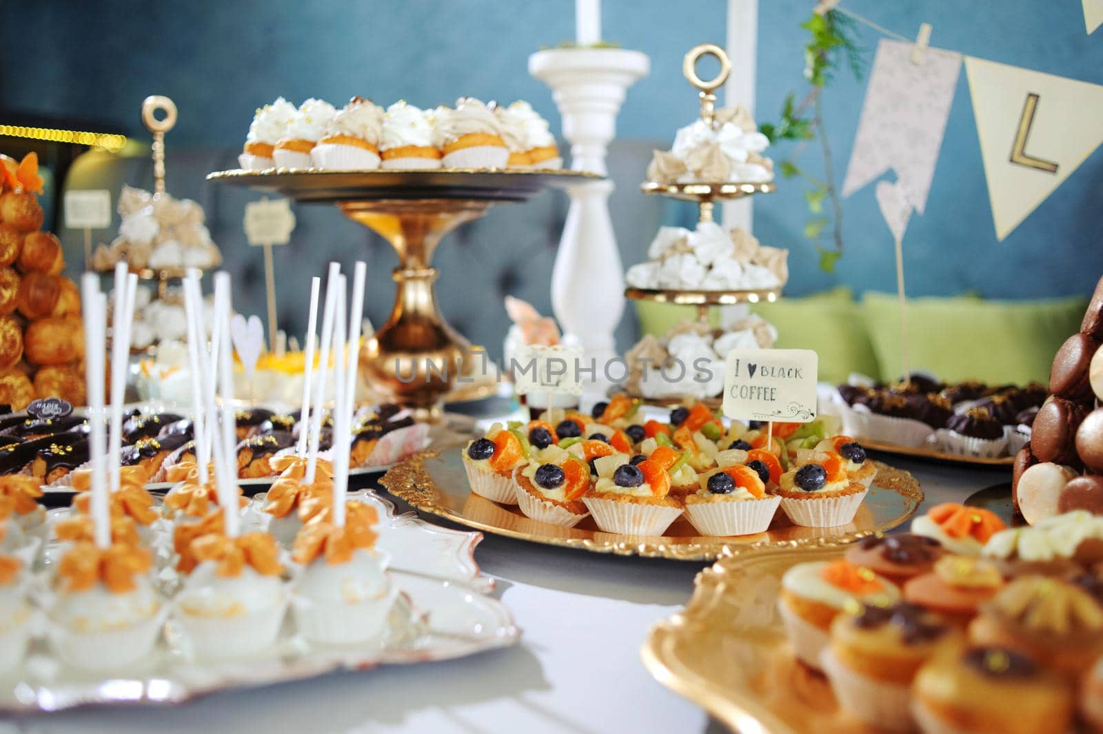 fruit tartlets on a golden tray, festive table with desserts.