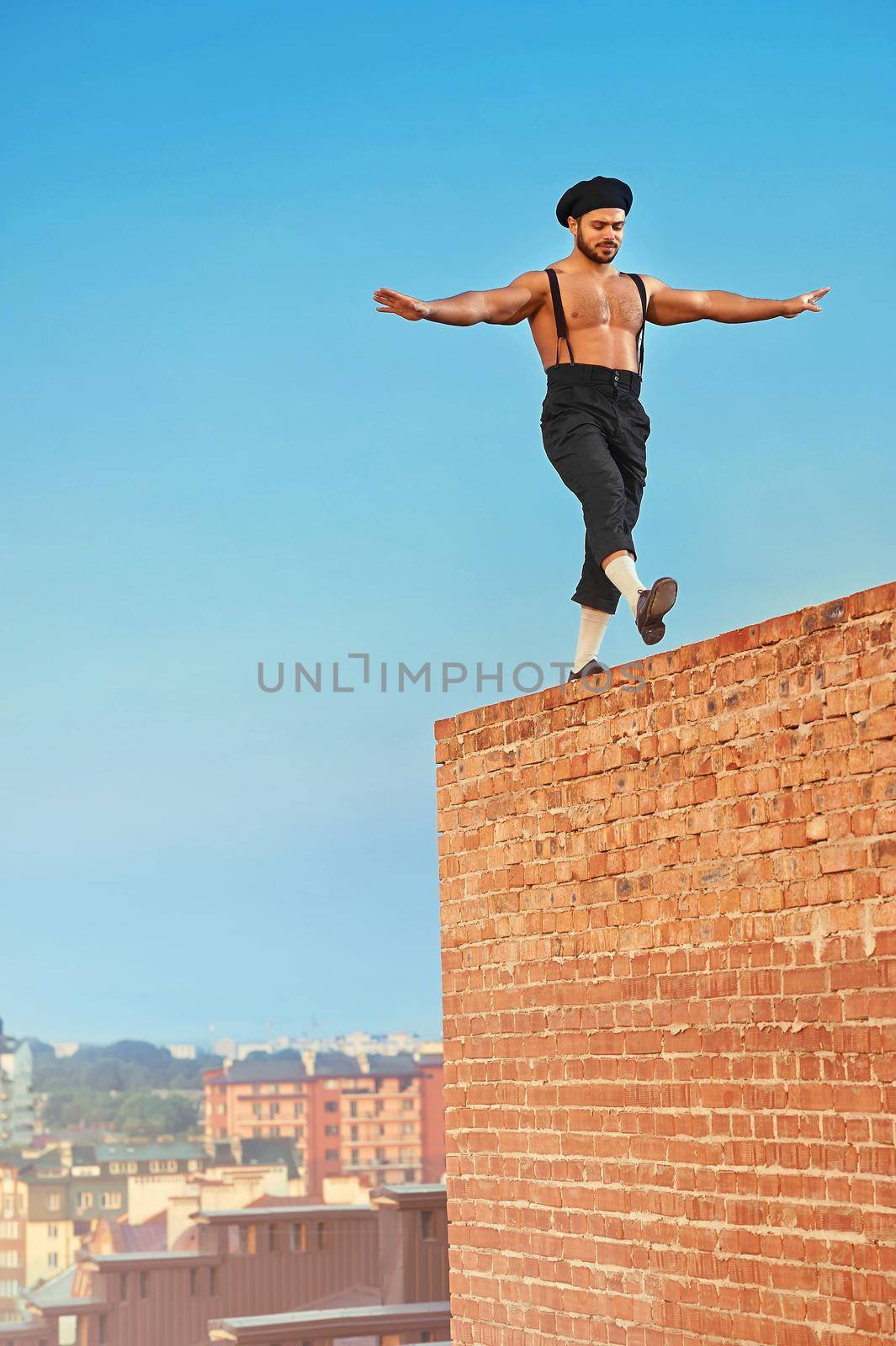 Balancing high. Shot of a shirtless retro male builder walking balancing on a brick wall