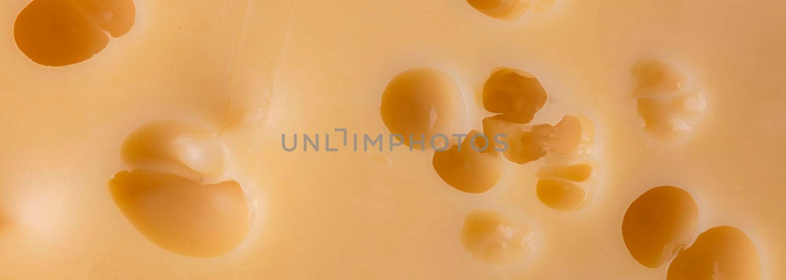 Cheese texture with large holes.Piece of cheese isolated by Sviatlana