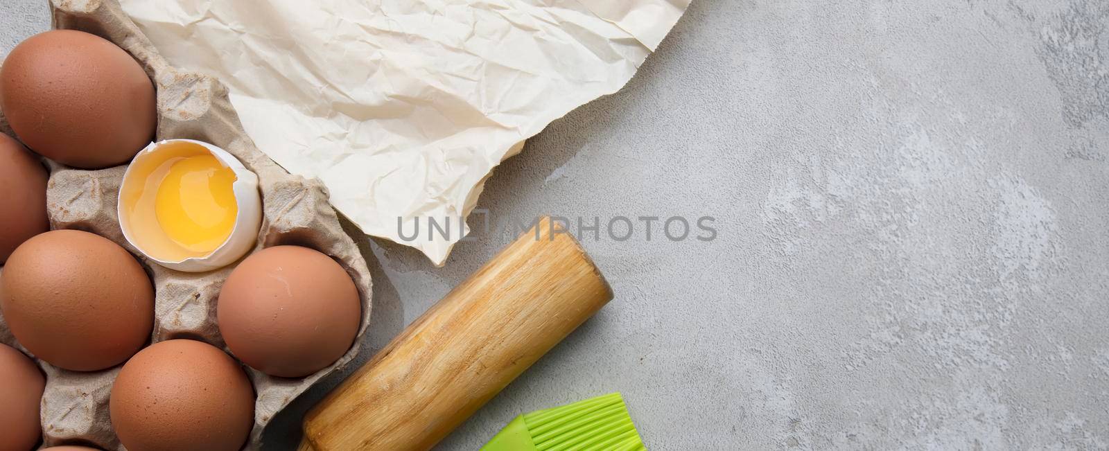 Baking cooking ingredients flour eggs rolling pin and kitchen textiles on gray concrete background. Cookie pie or cake recipe mockup