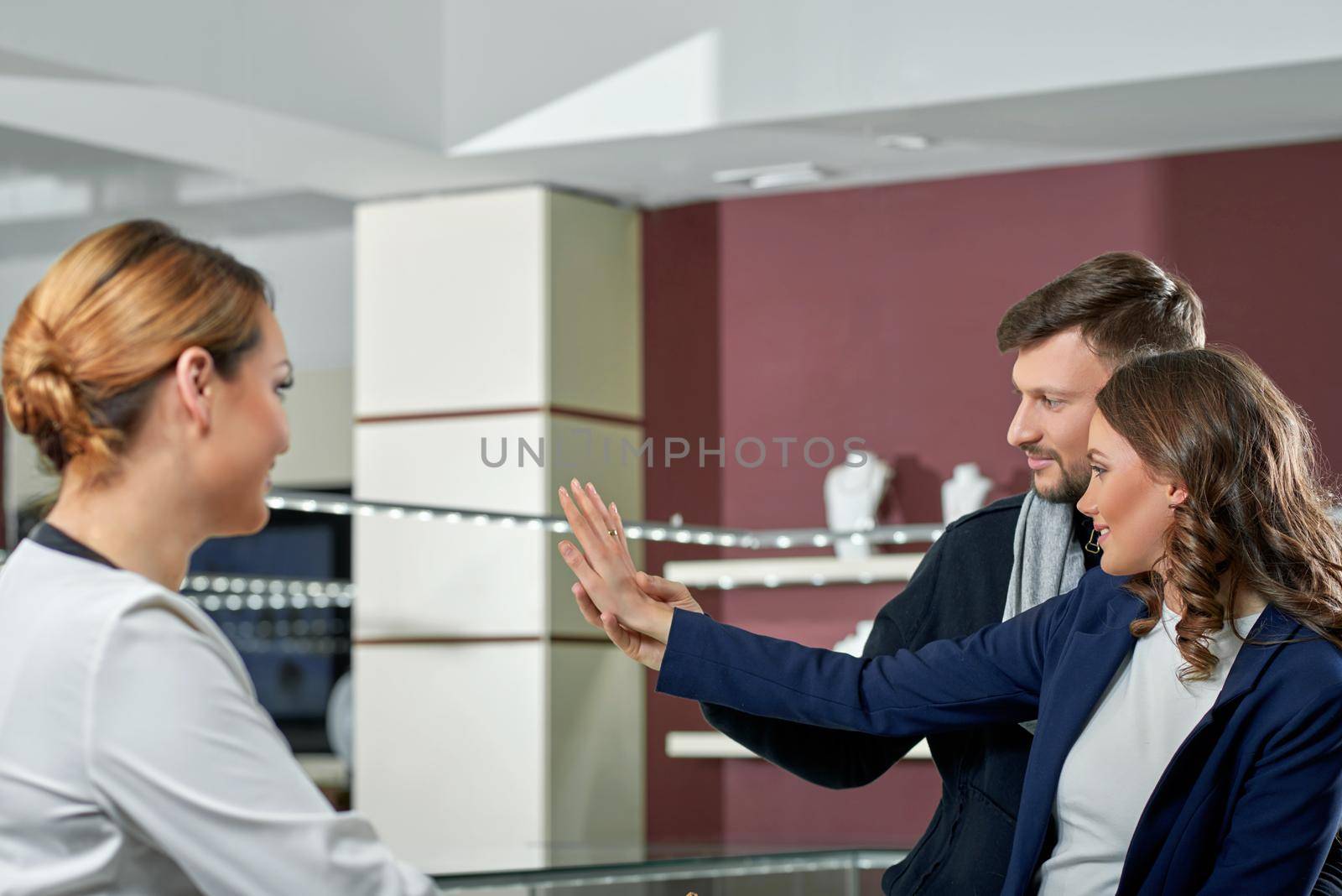 Lifetime accessory. Portrait of a handsome bearded man and his beautiful girlfriend buying a ring at the jewelry store