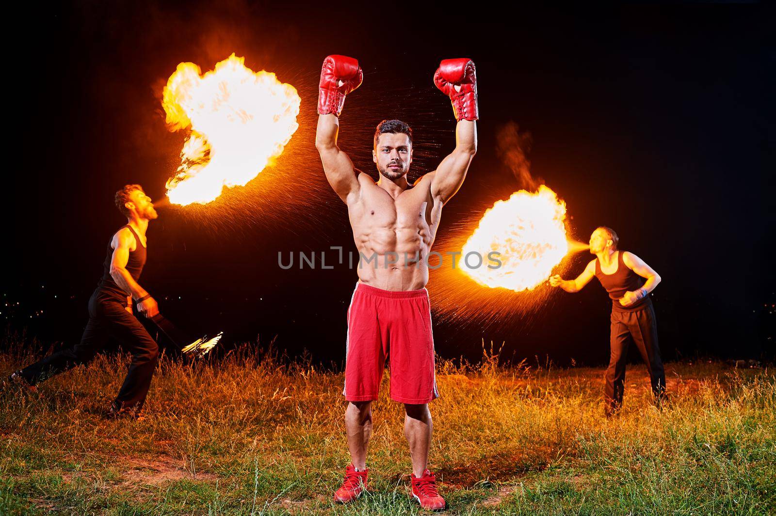 Ripped male boxer posing outdoors at night fire show performance by SerhiiBobyk