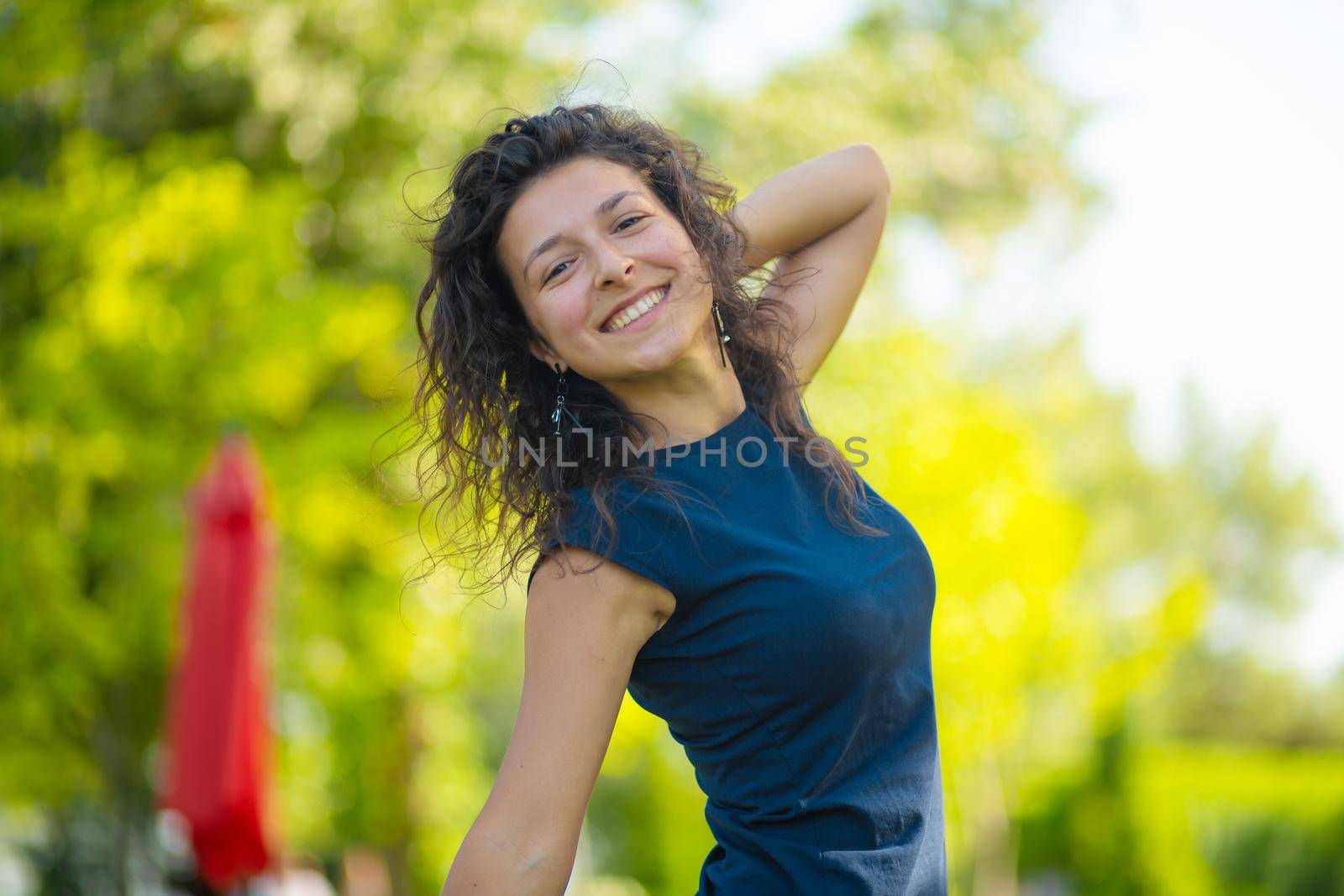 Portrait of young beautiful brunette enjoy bright summer day in green park.