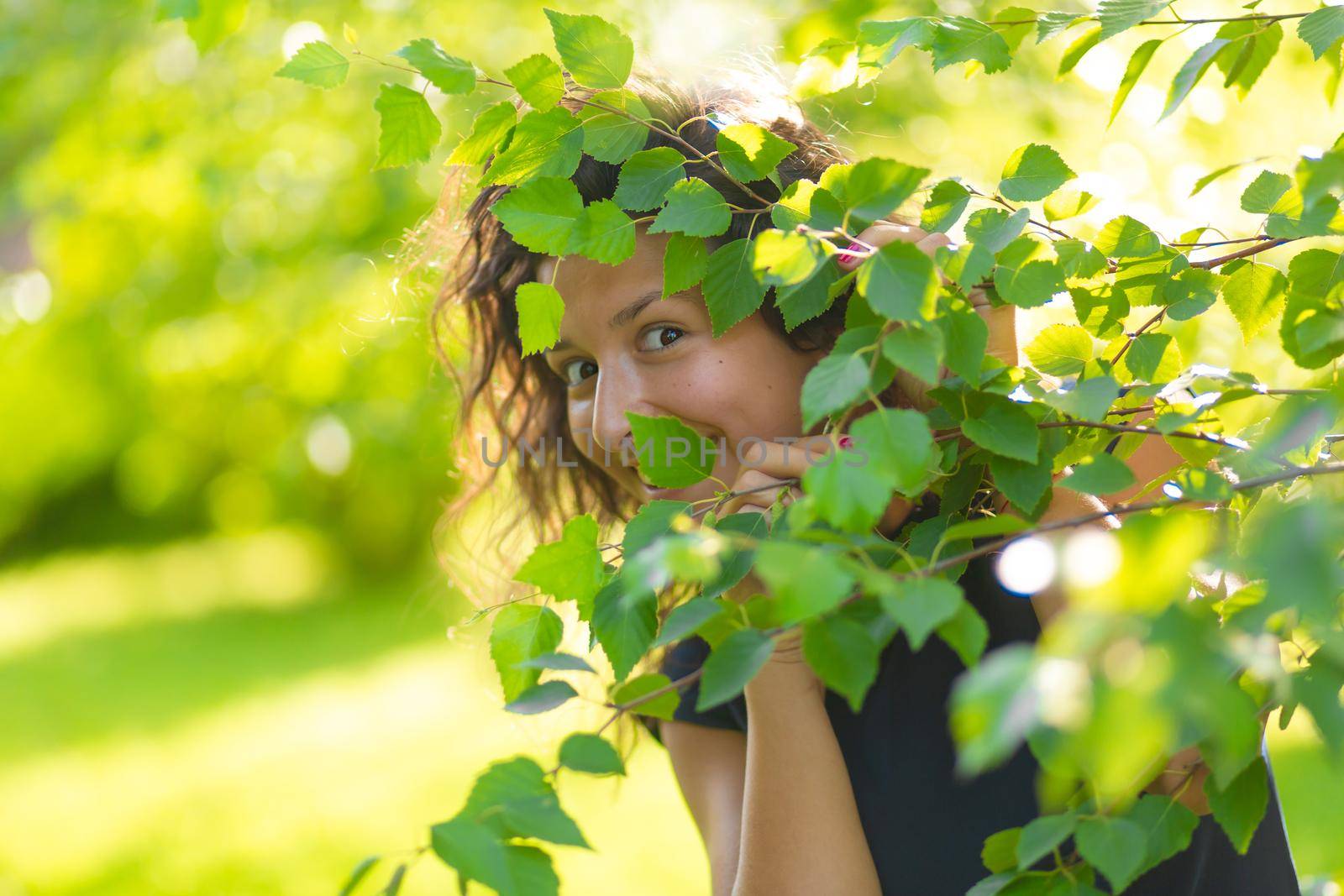 Portrait of young beautiful brunette enjoy walking in green summer park.